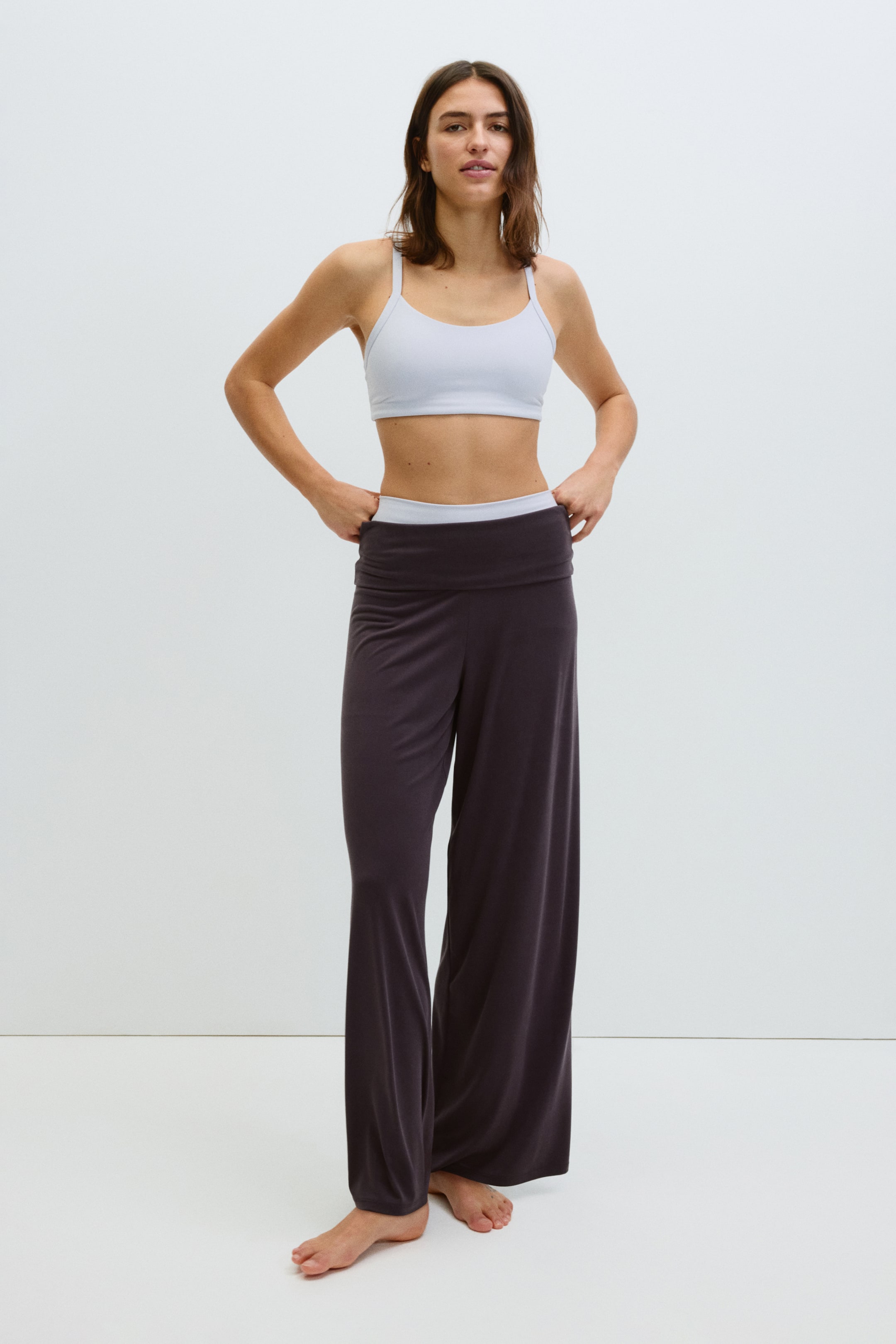Ver imagen más grande: Pantalones de pierna ancha en gris carbón que presentan una amplia cintura doblada en blanco contrastante y caen holgadamente desde las caderas hasta el suelo.