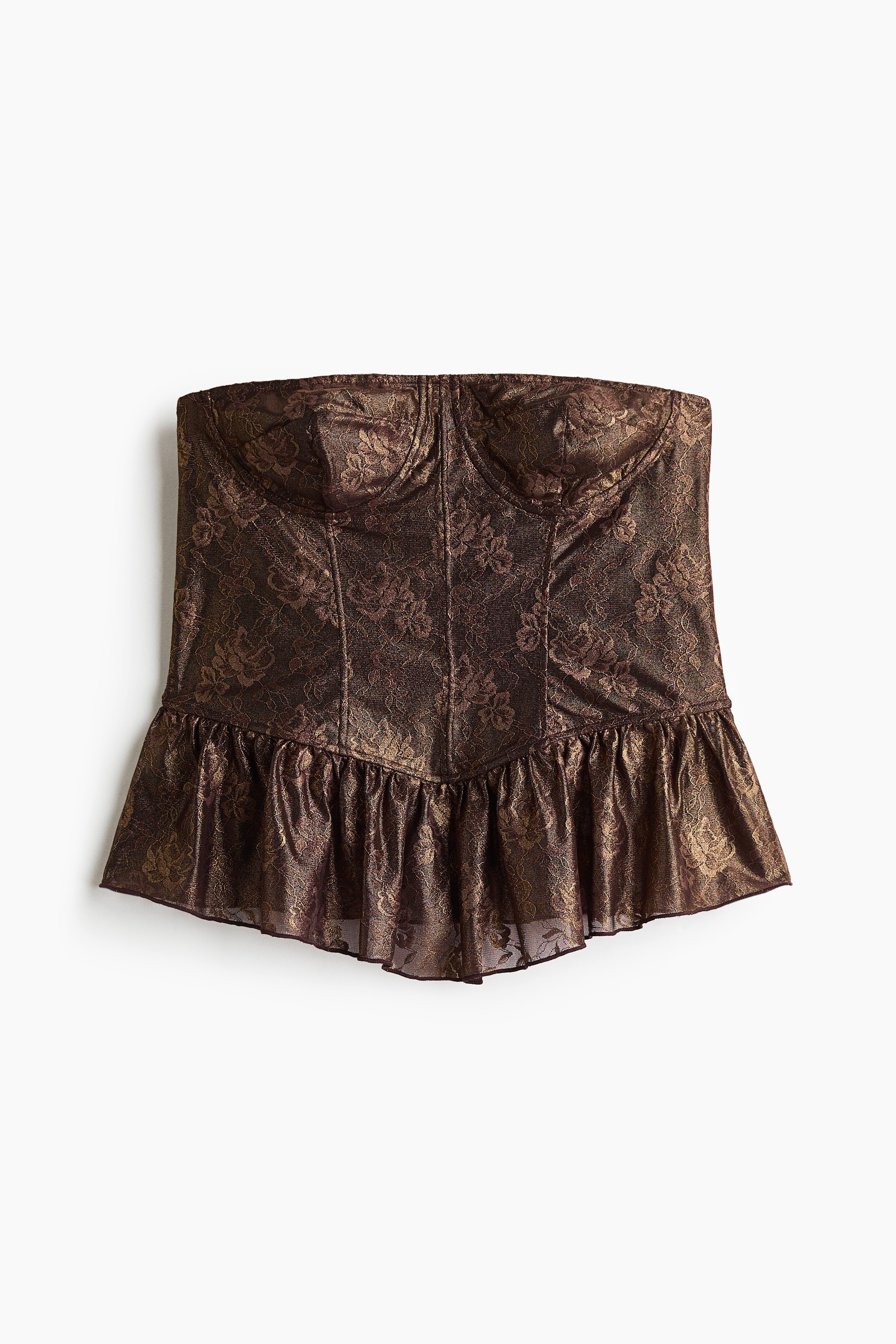 A fitted bandeau bustier top in dark metallic gold and black lace is worn by the model, featuring a structured sweetheart neckline with shaped cups and an angled, gathered peplum hem. The top is styled with brown satin trousers.