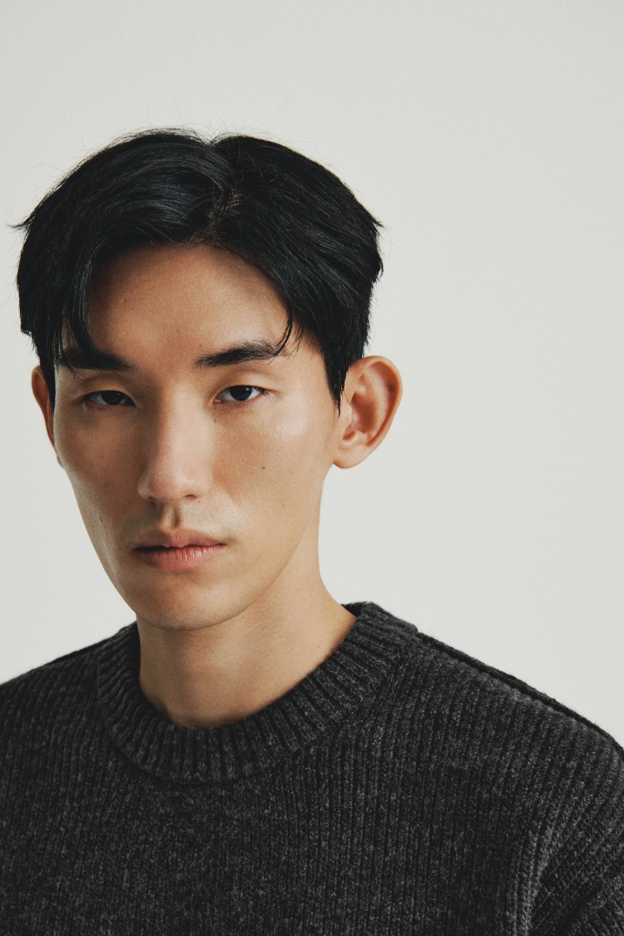 이미지 확대 보기: 어두운 회색 크루넥 스웨터가 착용 중이며, 몸 전체에 걸쳐 골지 니트 텍스처가 있으며 칼라는 꽉 끼는 골지 디자인입니다.