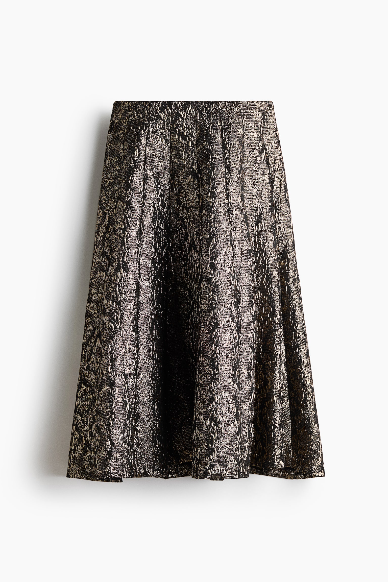 An A-line skirt featuring a metallic gold and black textured jacquard pattern is hanging from the front, showcasing a structured high waist and a flared, voluminous silhouette with deep pleats.