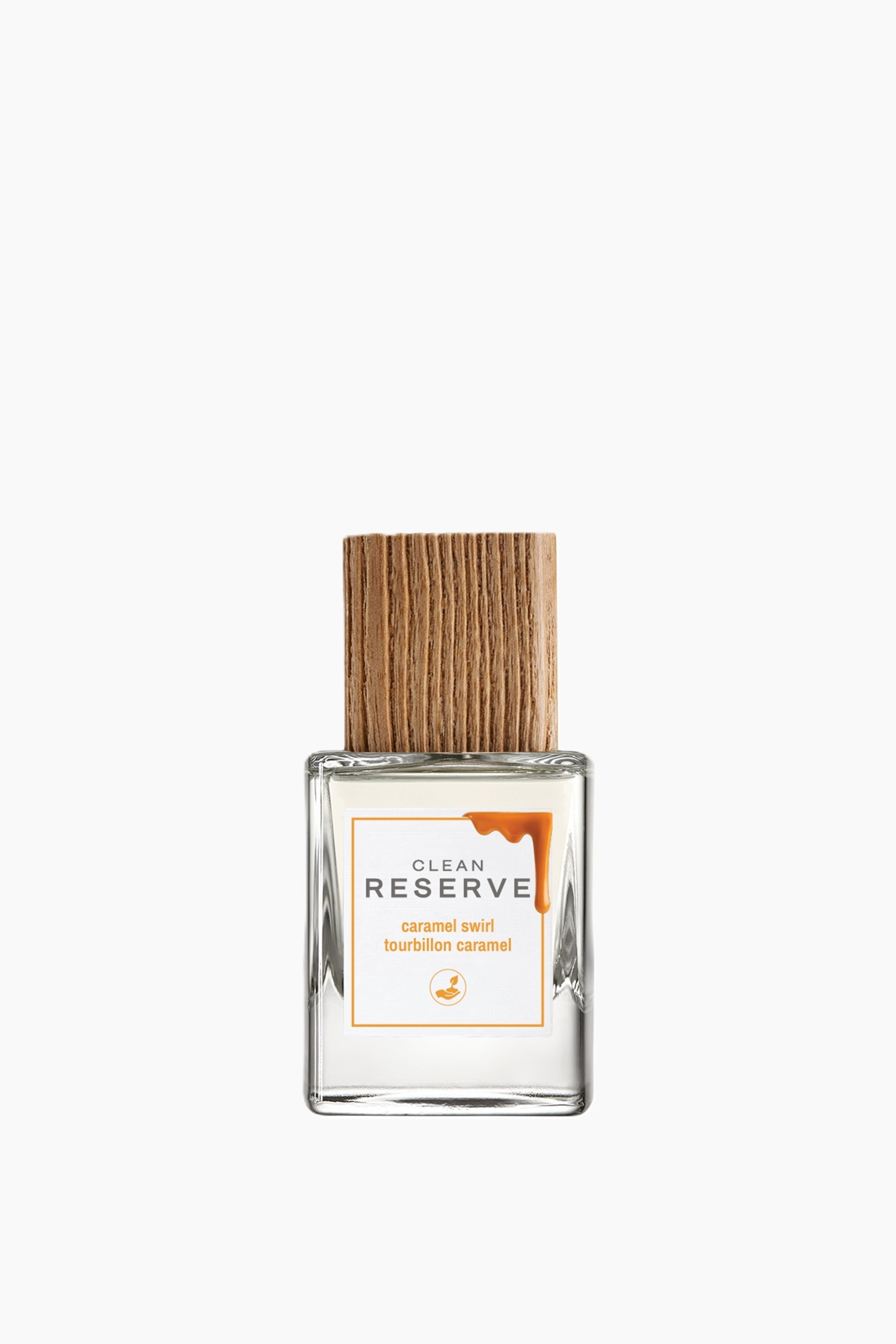 Visa större bild: Caramel Swirl Edp står upprätt och visar en rektangulär, klar glasflaska med ett texturerat ljusbrunt trälock på toppen. Flaskans framsida visar en vit fyrkantig etikett med orange text och en grafik av rinnande karamell.