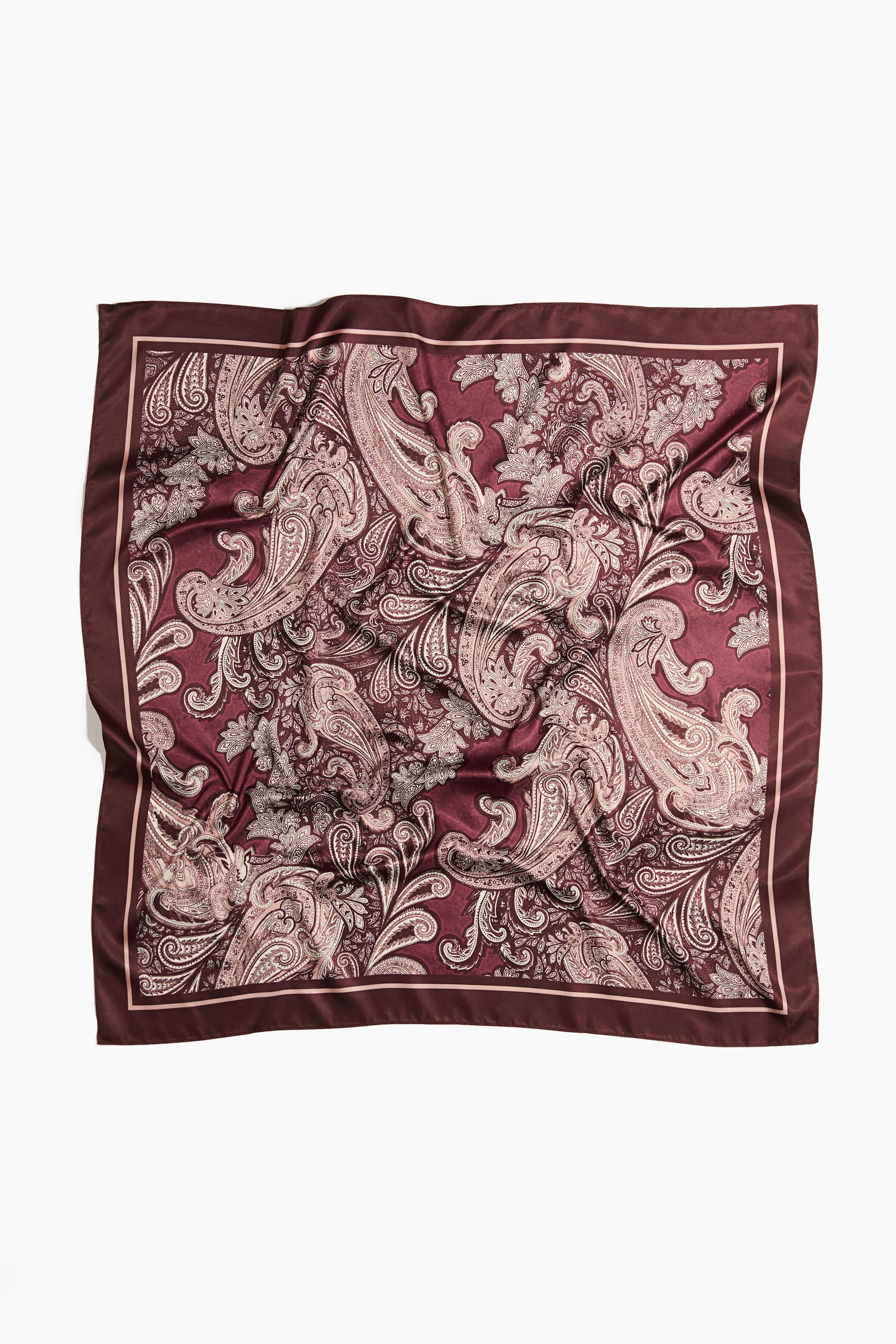 Agrandir l'image: Un foulard carré est posé à plat, présentant une base bordeaux ornée d’un motif cachemire complexe dans des tons rose pâle et beige. Il est doté d’une bordure extérieure bordeaux unie et d’une bordure intérieure rose pâle plus fine.