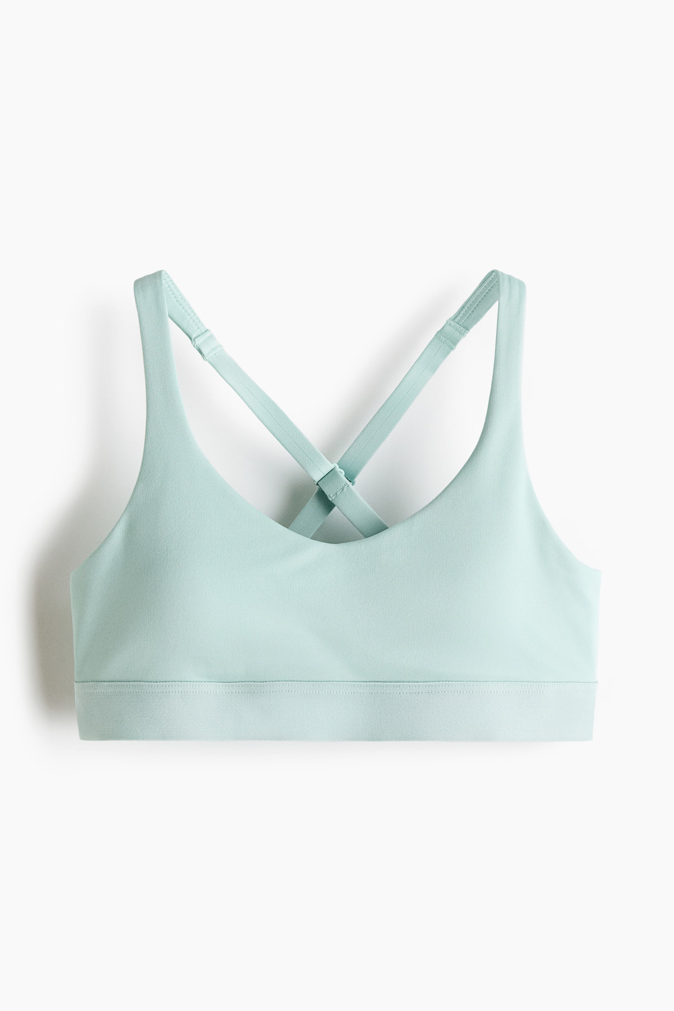 Voir une image plus grande: Un haut de sport vert menthe clair est présenté de face, avec un décolleté arrondi, une large bande élastiquée à la base et des bretelles ajustables conçues pour se croiser dans le dos.