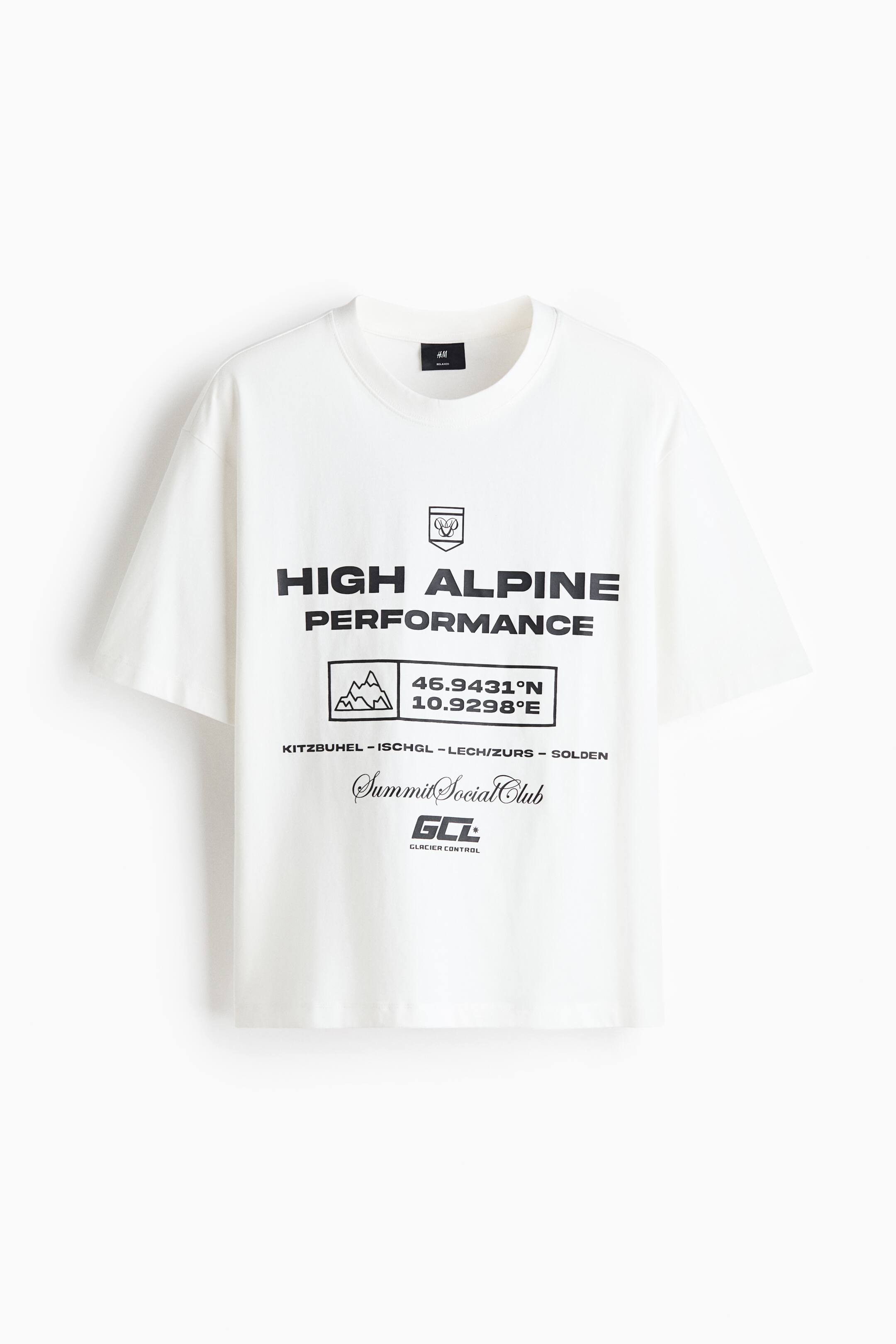 View larger image: A white crew neck T-shirt is shown from the front, featuring a relaxed fit and wide short sleeves. The chest displays a black graphic print that includes the bold text "HIGH ALPINE PERFORMANCE" along with geographic coordinates, a mountain graphic, and alpine-themed text.