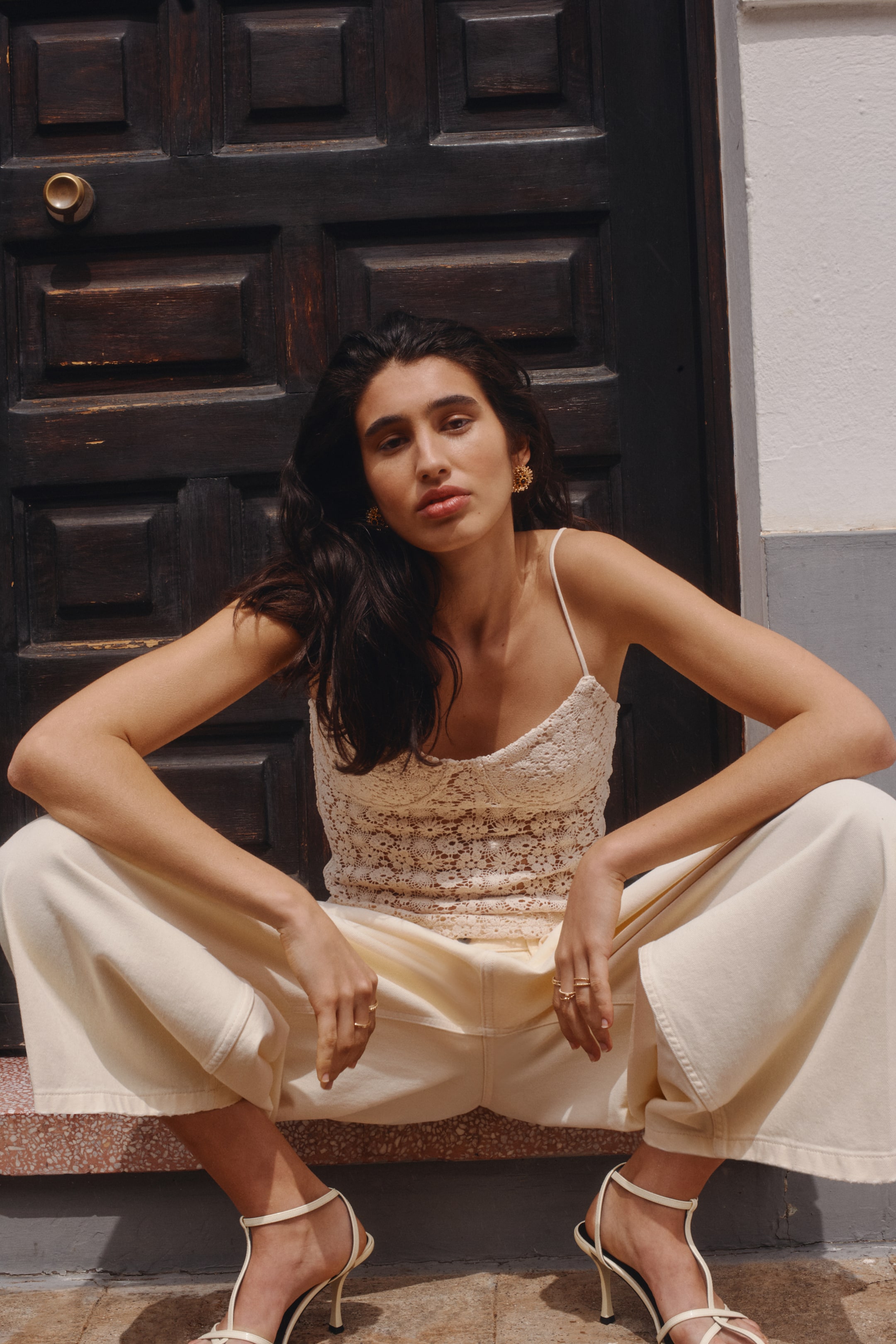 Visa större bild: En kort, figursydd topp visas framifrån, med ett virkat utseende i bomullsstickning. Den har en hjärtformad ringning, smala axelband och formade, jerseyfodrade kupor.