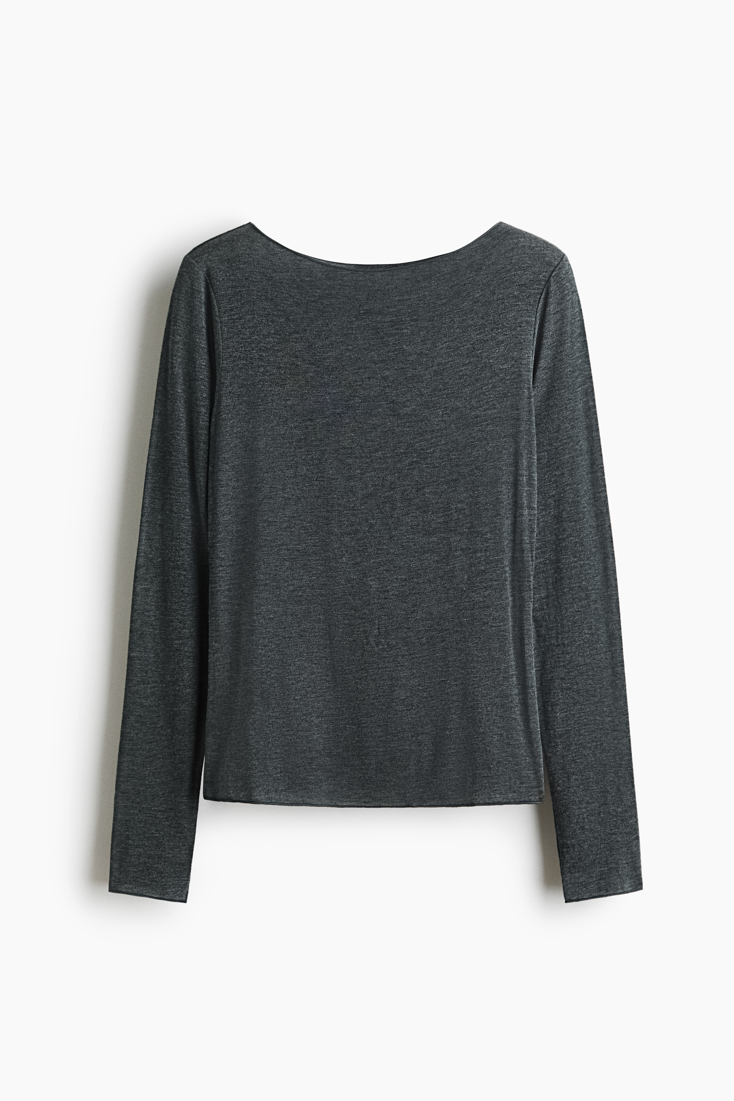 En mørk grå, langermet jerseytopp med båthals er brukt av modellen, som kombinerer den med matchende vide bukser. Den figursydde toppen er lett rynket nederst mens modellen hviler hendene sammen ved midjen.