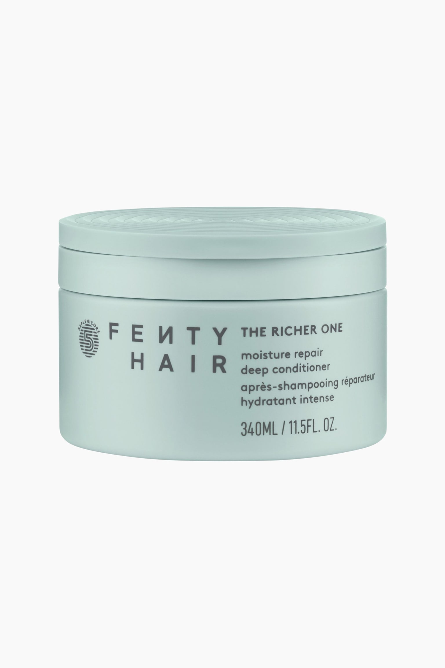 The Richer One Moisture Repair Deep Conditioner stÃ¥r i en frontvendt position og fremstÃ¥r som en cylindrisk, lyse mintgrÃ¸n krukke med et matchende lÃ¥g, der har koncentriske cirkulÃ¦re riller pÃ¥ toppen. Forsiden af krukken viser mÃ¸rkegrÃ¥ trykt tekst, der inkluderer "FENTY HAIR" og "THE RICHER ONE moisture repair deep conditioner."