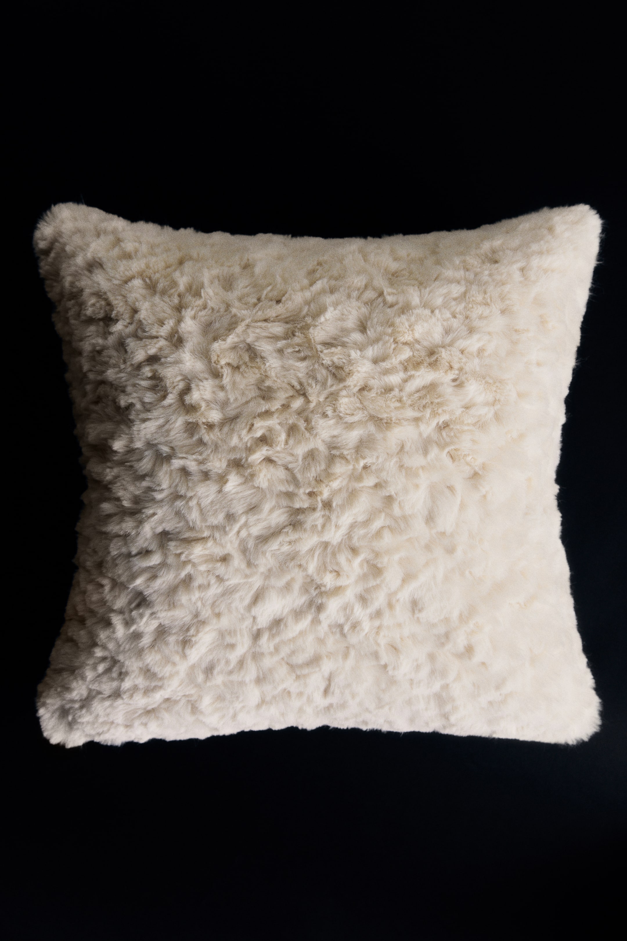 View larger image: A square cushion cover made from a soft, fluffy off-white fabric is shown from the front, highlighting a highly textured, curly faux fur pile.