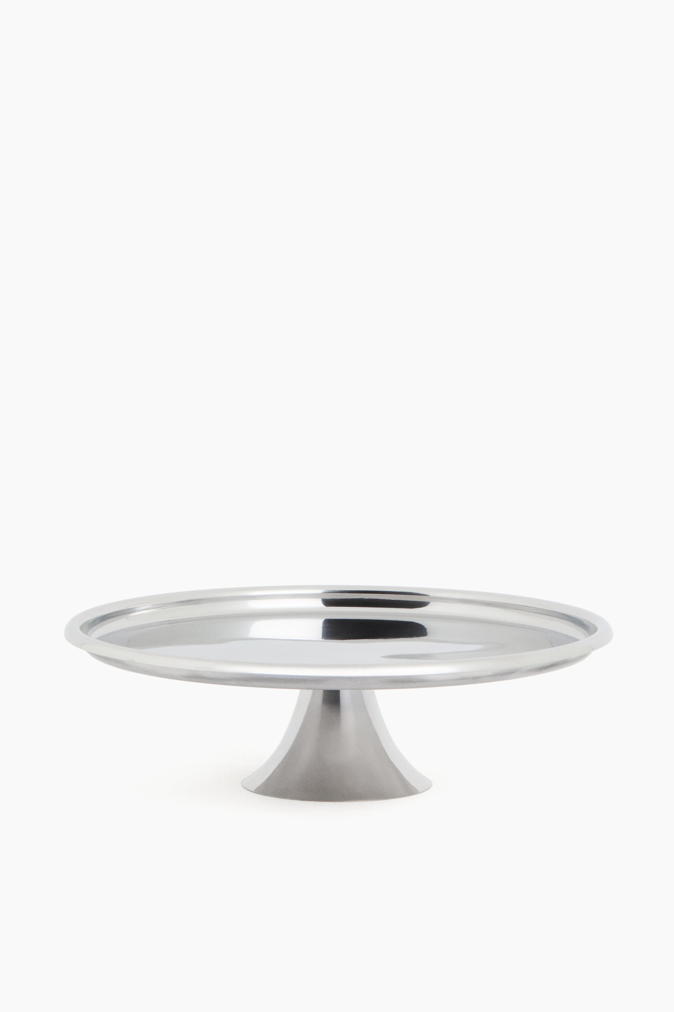 View larger image: A silver-toned cake stand featuring a circular, highly reflective top with a raised edge and a conical base with a brushed metal finish.