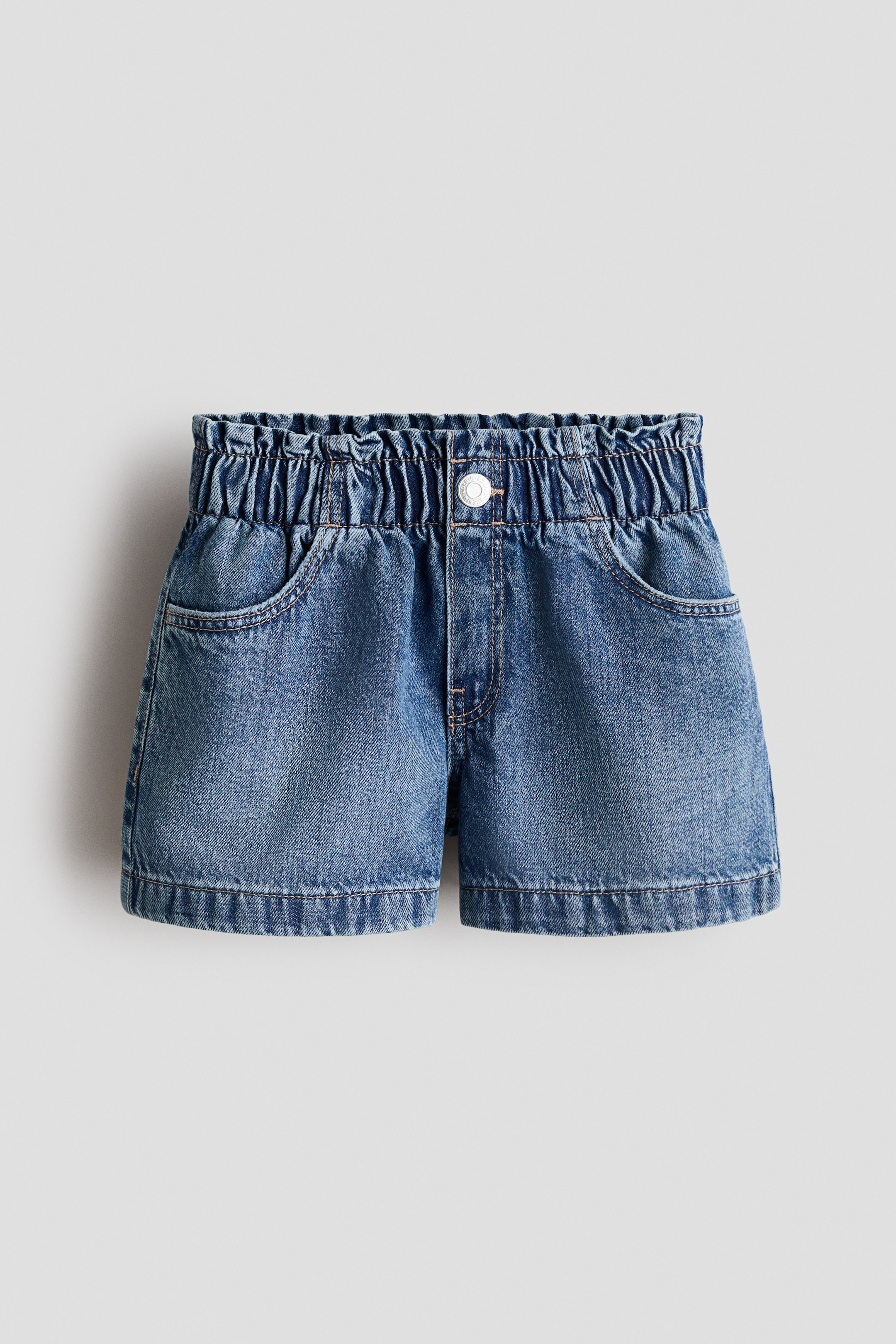 Xem ảnh lớn hơn: Quần short dáng rộng màu xanh denim đã giặt đang khoe MẶT TRƯỚC, nổi bật với cạp chun kiểu túi giấy, khóa giả với nút bấm bạc, và túi trước chéo.