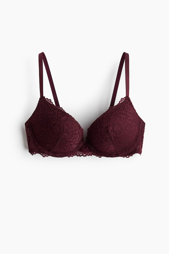 A maroon lace super push-up bra is displaying from the front. It is featuring adjustable shoulder straps, underwired thickly padded cups with an intricate floral pattern, and a decorative lace underband. - 1