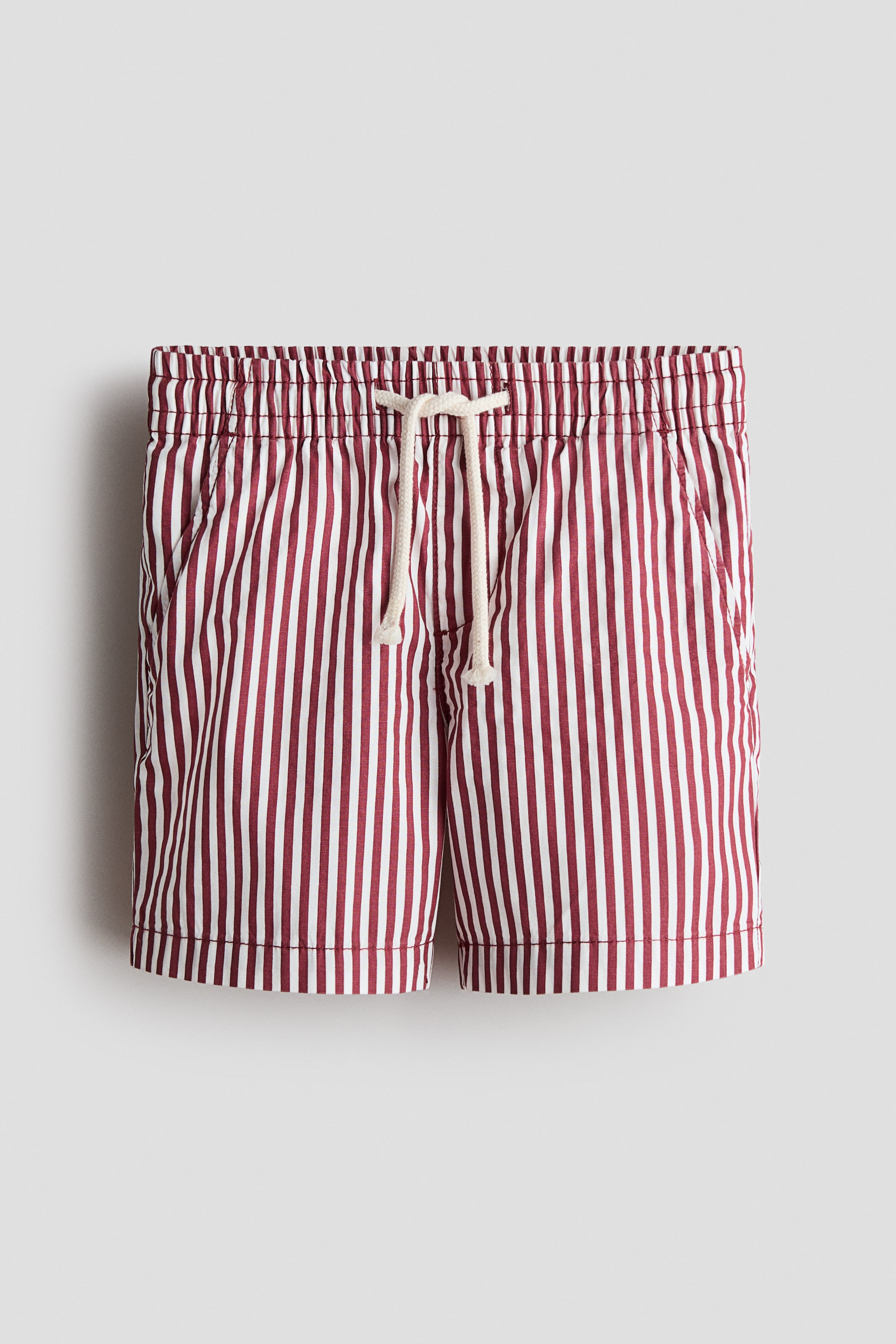 View larger image: The shorts showcase a front view, highlighting a maroon and white vertical stripe pattern on a soft cotton weave. They are crafted with an elasticated waist, a light-coloured drawstring tied at the front, a faux fly, and diagonal side pockets.