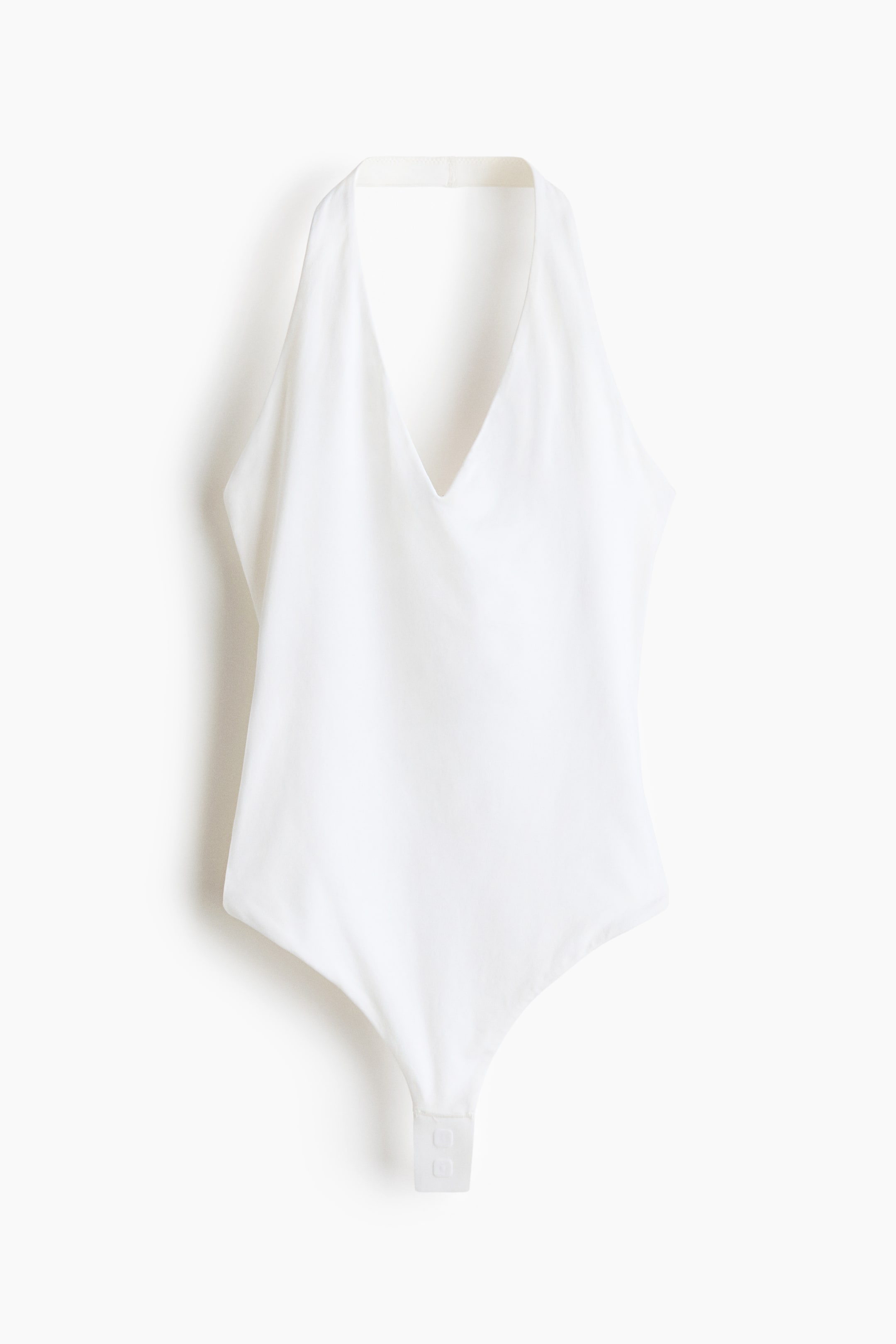 View larger image: A white bodysuit is showcased front-facing, featuring a deep V-neckline and a halter-style neck strap. Its smooth fabric displays a snap closure at the crotch.
