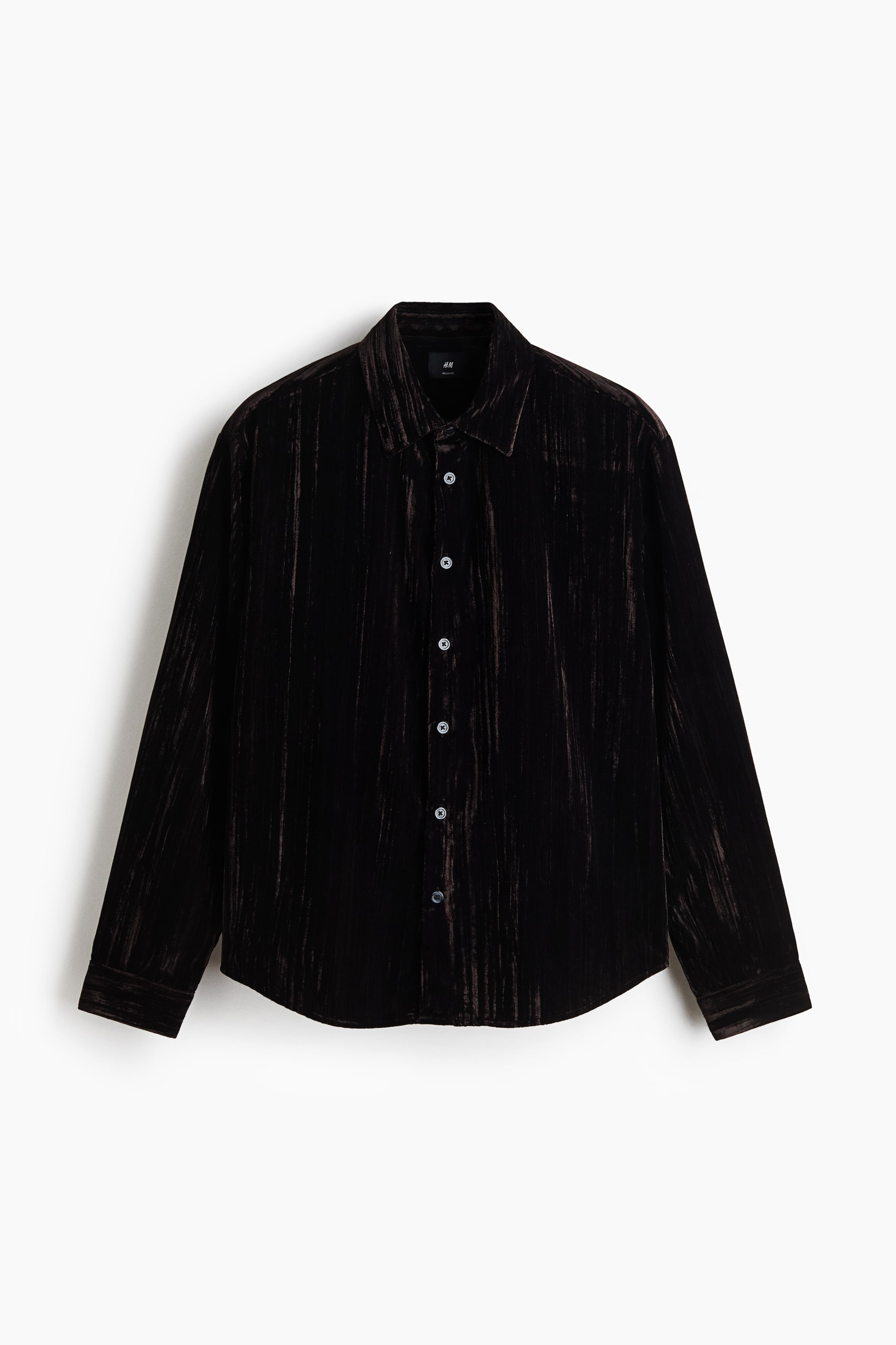 View larger image: A dark brown, textured velvet button-down shirt is facing front, displaying a subtle vertical sheen. It features a standard collar, a front placket with contrasting grey buttons, and long sleeves with buttoned cuffs.