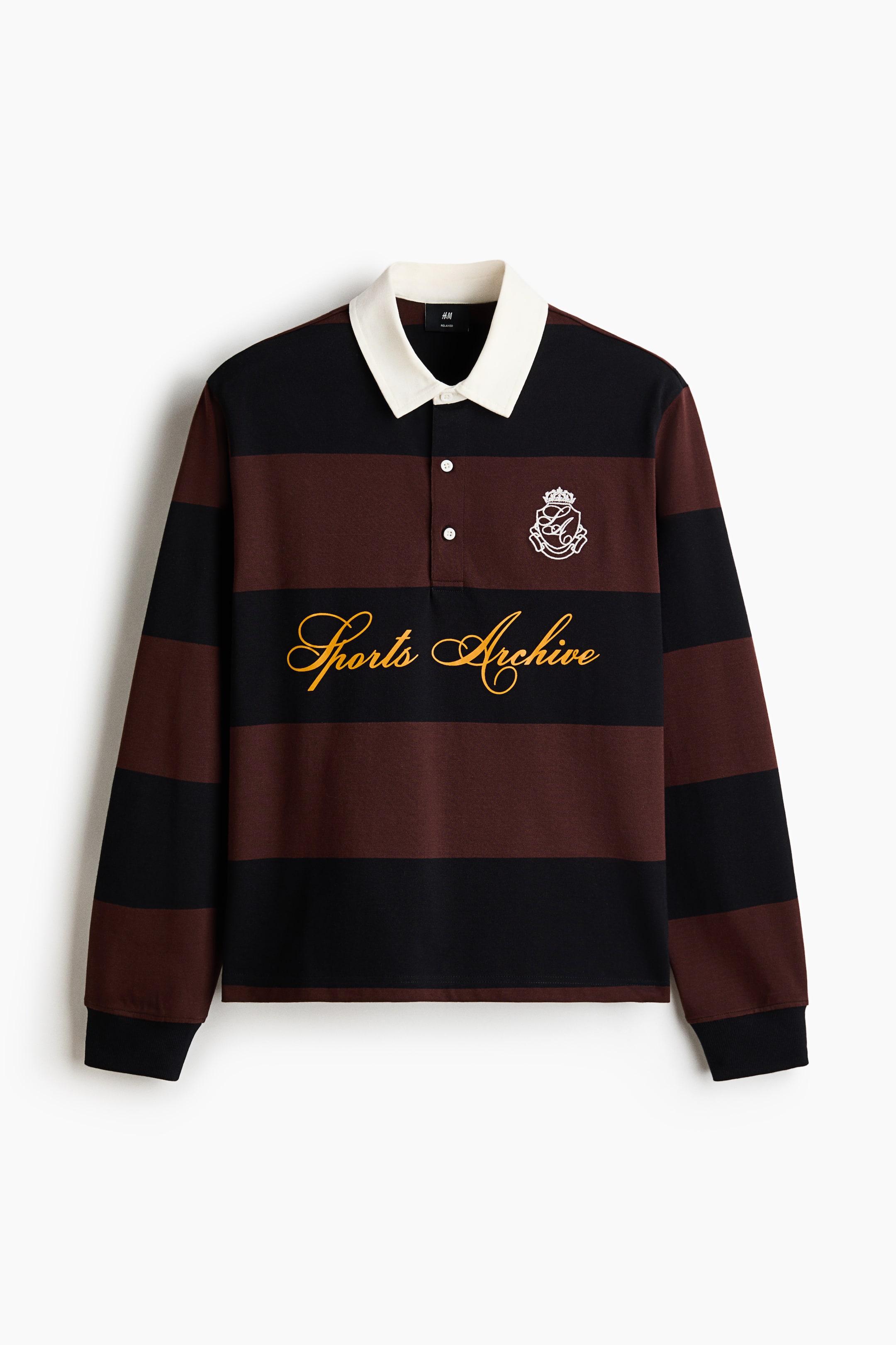 View larger image: A long-sleeved rugby shirt is shown from the front, featuring wide horizontal stripes in black and dark brown with a contrasting white collar and a two-button placket. The shirt displays a white embroidered crest on the left chest, yellow cursive text reading "Sports Archive" across the centre, and black ribbed cuffs.