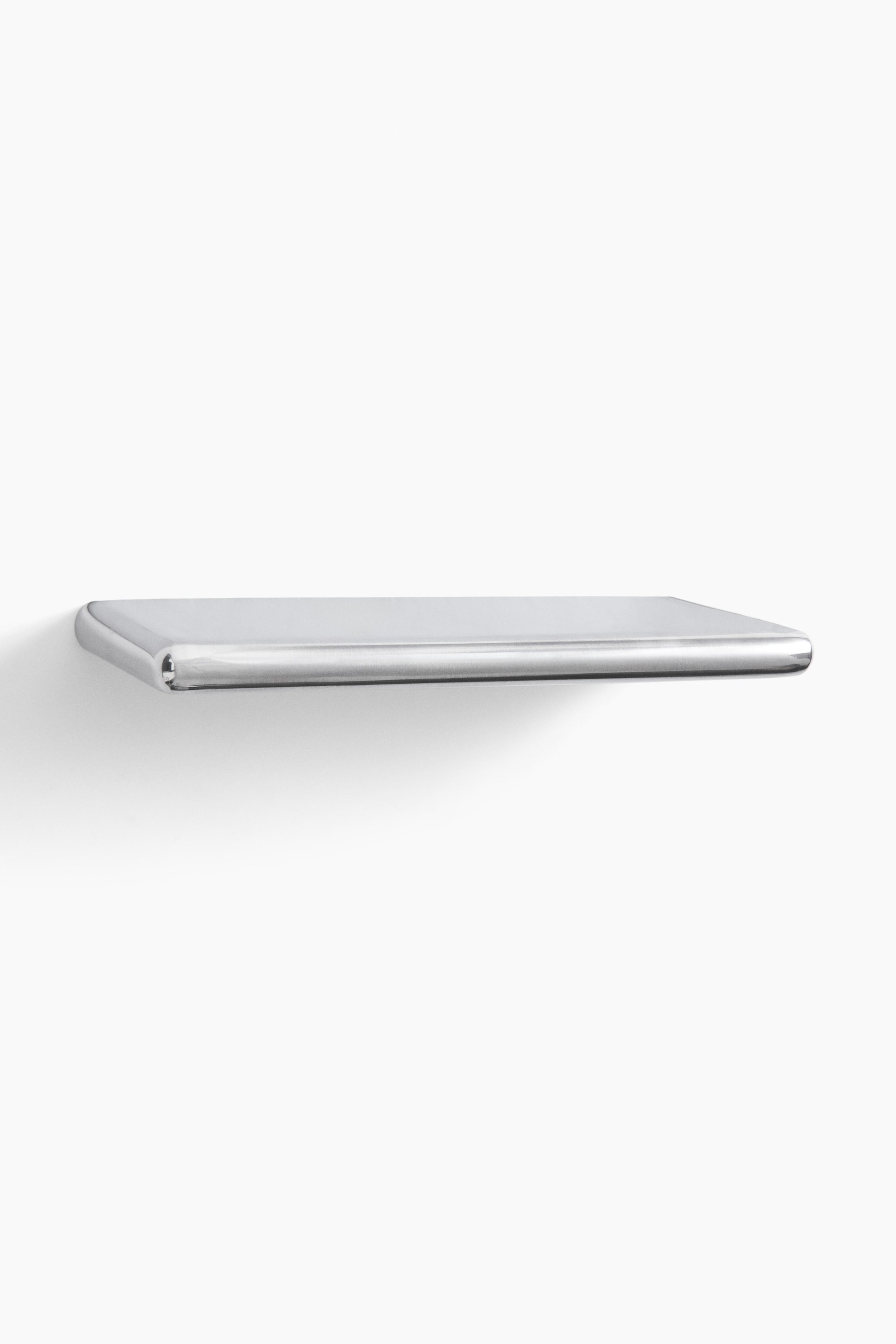 Agrandir l'image: Une étagère rectangulaire en chrome poli s’étend horizontalement, avec des bords arrondis sur l’avant et les côtés.