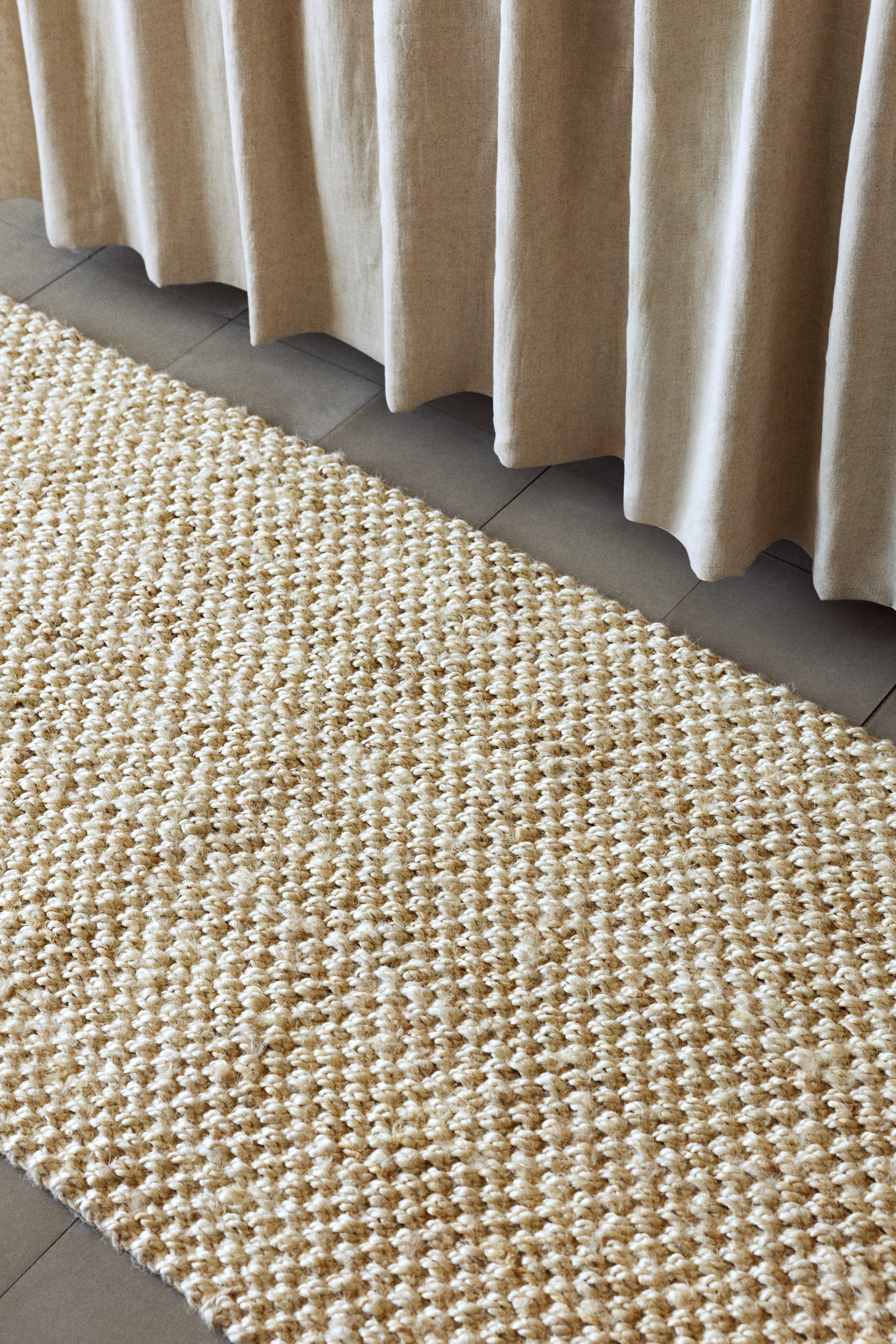 Größeres Bild anzeigen: Ein Läufer aus Naturfasern präsentiert eine dicht gewebte, noppige Textur in verschiedenen Schattierungen von hellem Beige, die sich diagonal über das Bild erstreckt.