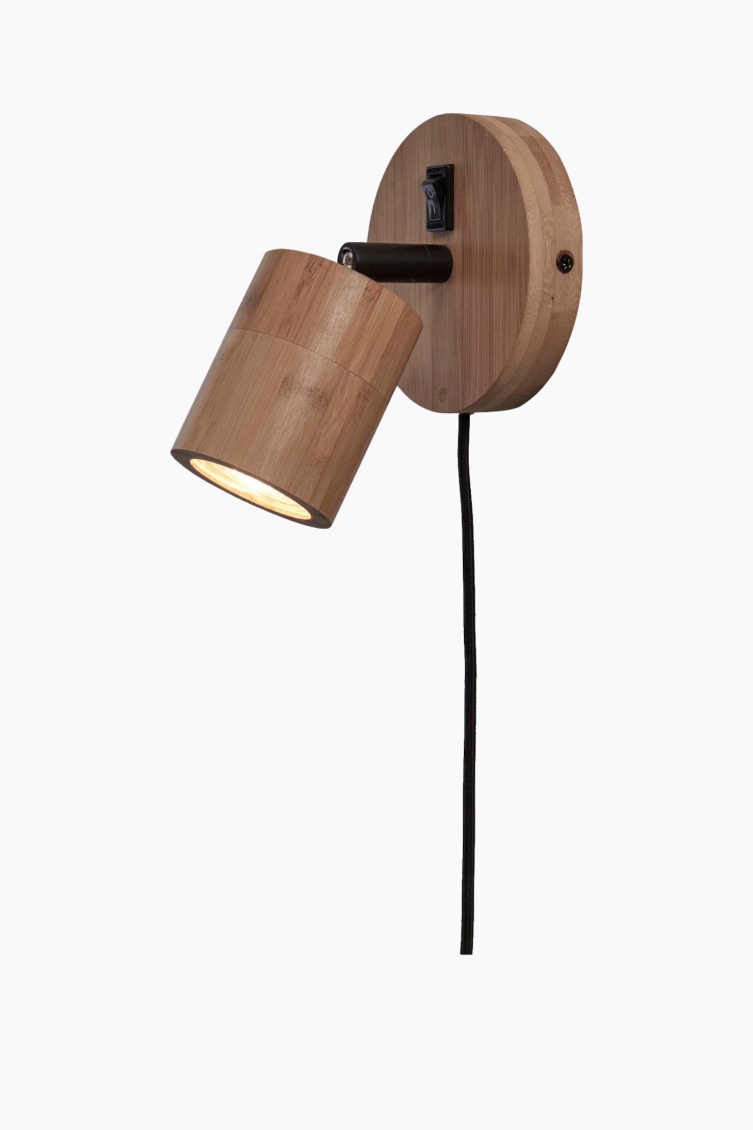 Deze wandspot heeft een ronde houten achterplaat en een verstelbare cilindervormige kap, vervaardigd uit lichtgekleurde houtsoort. De kap is naar beneden en naar links gericht en verspreidt warm licht, terwijl een zwarte stroomkabel recht naar beneden hangt vanaf de basis van de achterplaat. - 1
