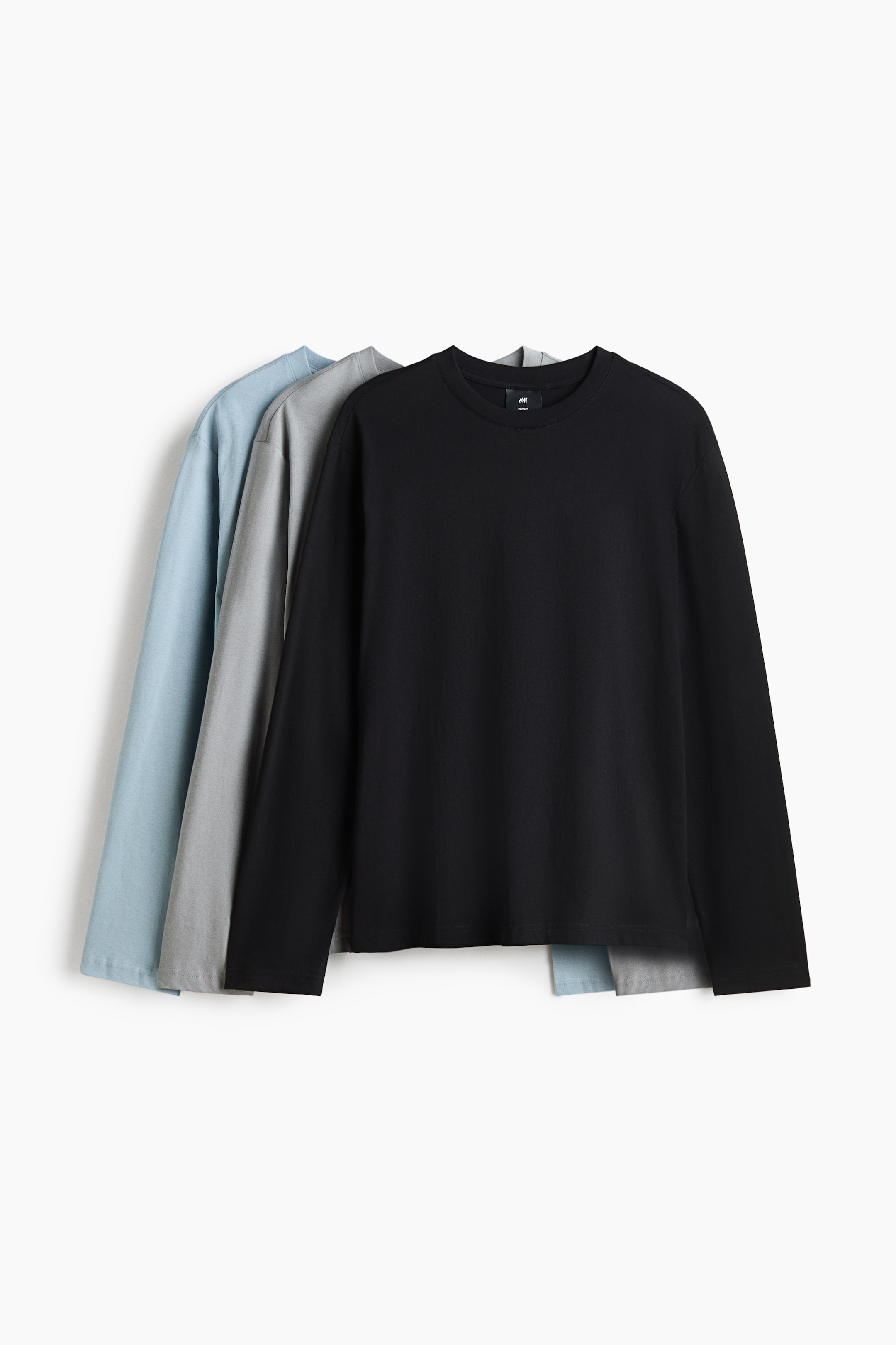 View larger image: Three long-sleeved cotton jersey tops are layered from the front to showcase black, grey, and light blue colour options. Each top features a regular-fit silhouette with a round, rib-trimmed neckline, long sleeves, and a straight-cut hem.