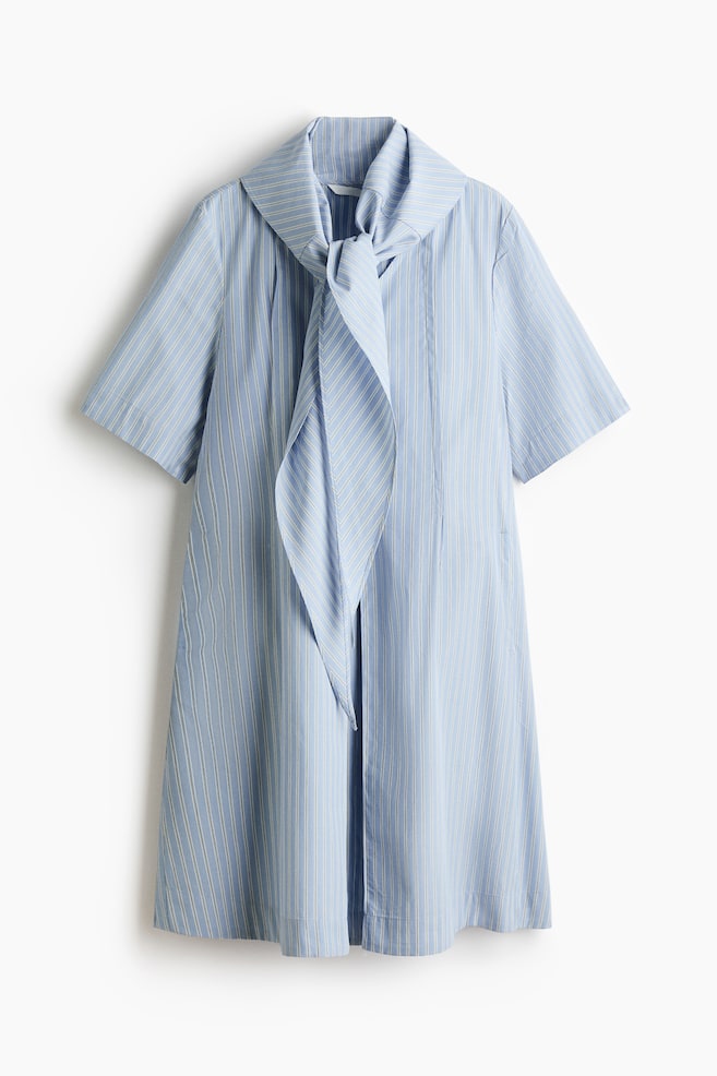 A light blue dress with thin white vertical stripes is featuring a wide, draped collar tied in a knot at the front, short, loose sleeves, and a straight, relaxed silhouette. - 1