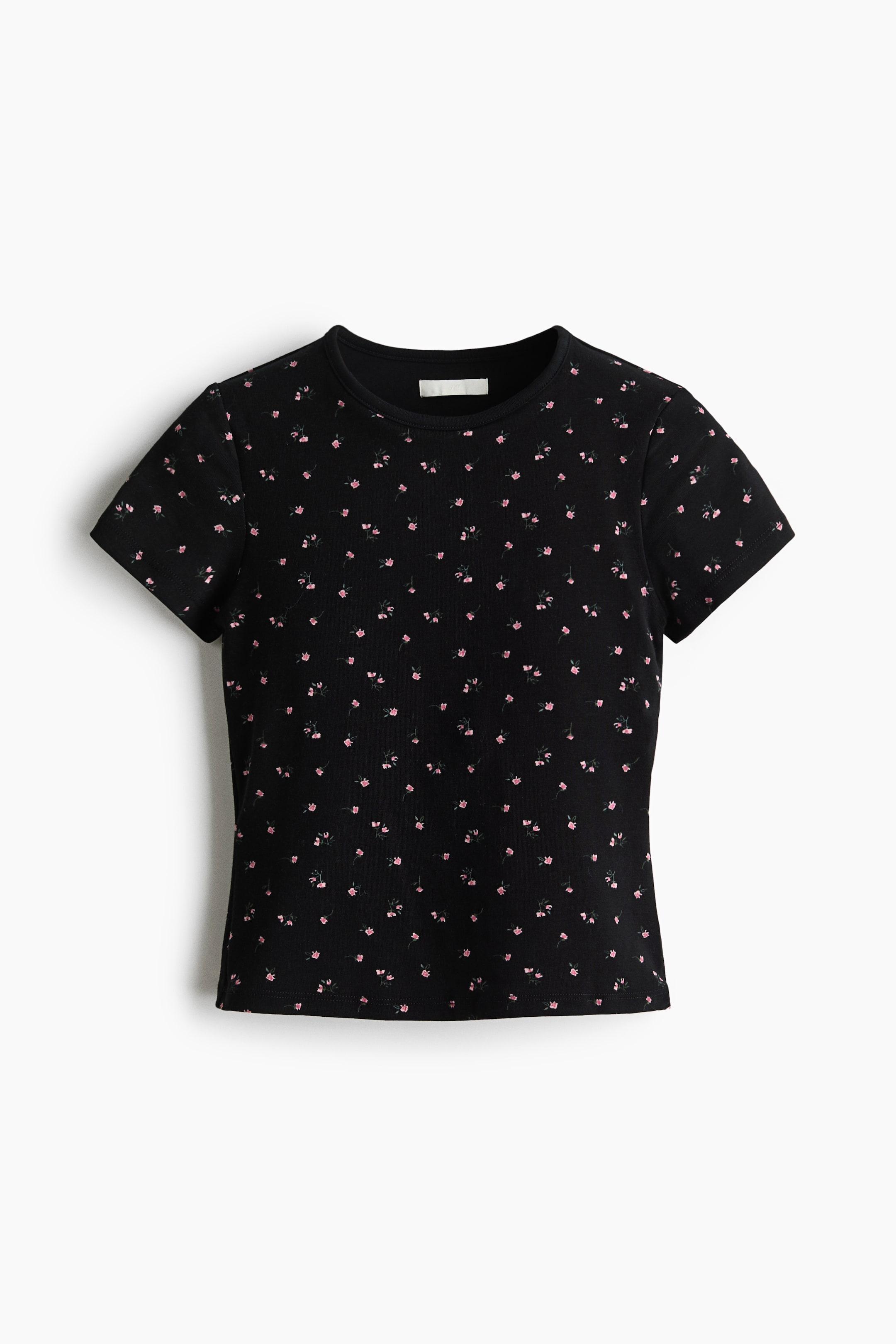 拡大画像を表示: 全面に小さなピンクの花柄をあしらったブラックのフィットTシャツを正面から見せており、丸首、半袖、ストレートな裾が確認できます。