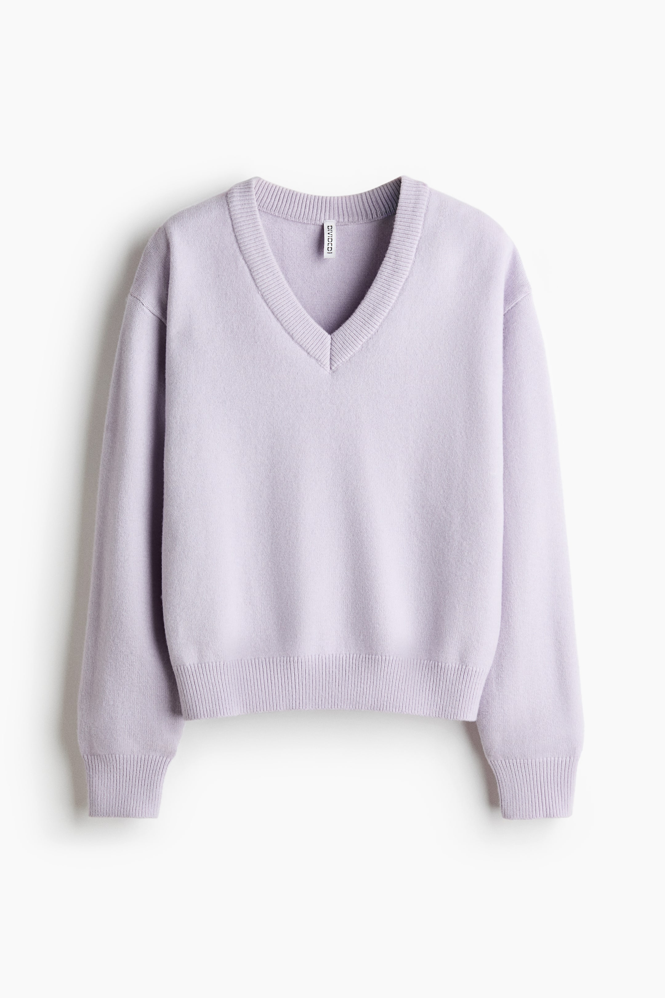 Agrandir l'image: Un pull en maille violet clair est suspendu de face, mettant en valeur un col V côtelé, des épaules tombantes et des manches longues. Le pull présente des finitions côtelées aux poignets et à l’ourlet.