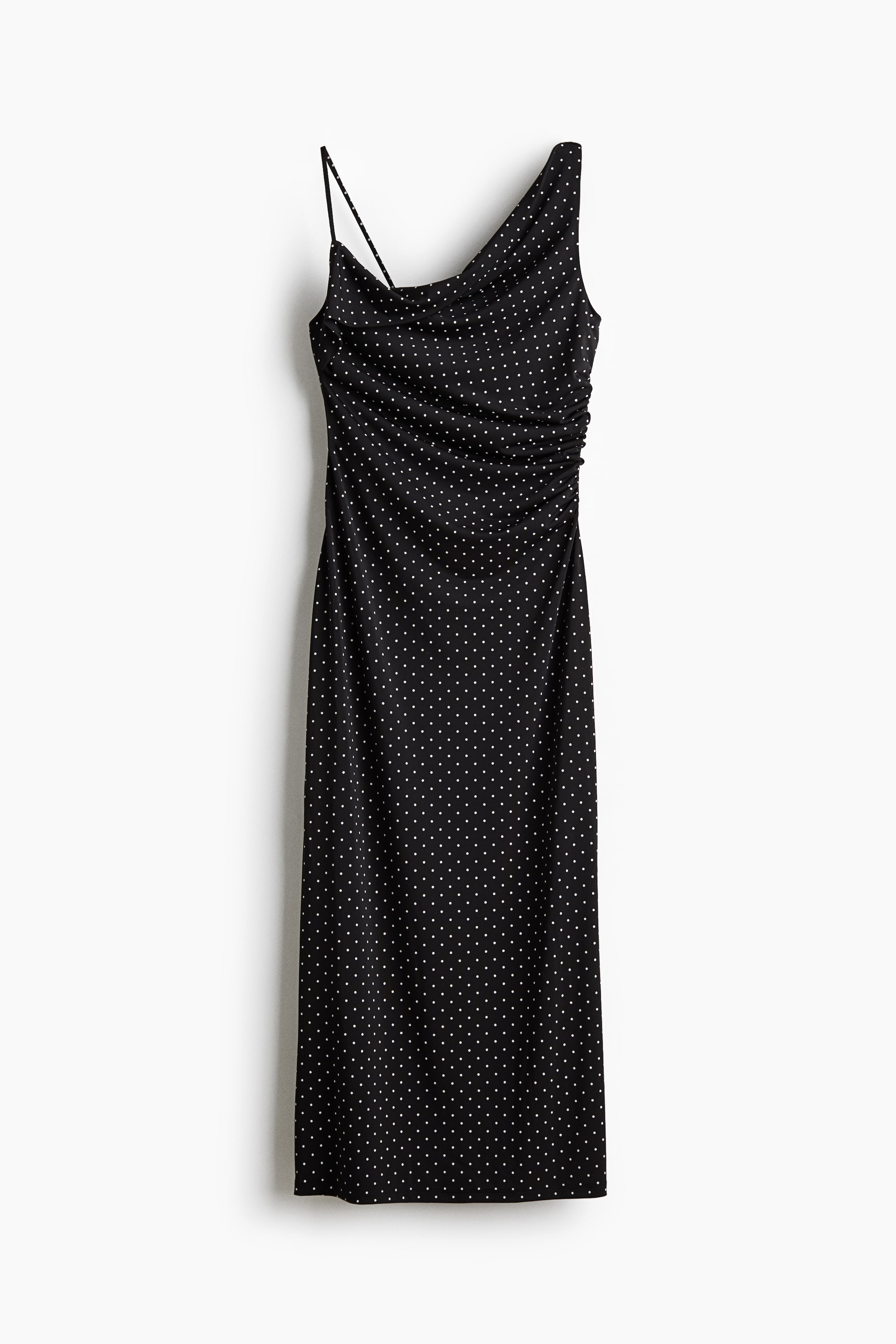 Ampliar la imagen: Se muestra de frente un vestido negro entallado hasta media pantorrilla con un patrón de lunares blancos, que destaca un escote asimétrico con un tirante delgado tipo espagueti y un tirante ancho. El vestido presenta un drapeado fruncido a un lado de la cintura y cae en un dobladillo de corte recto.