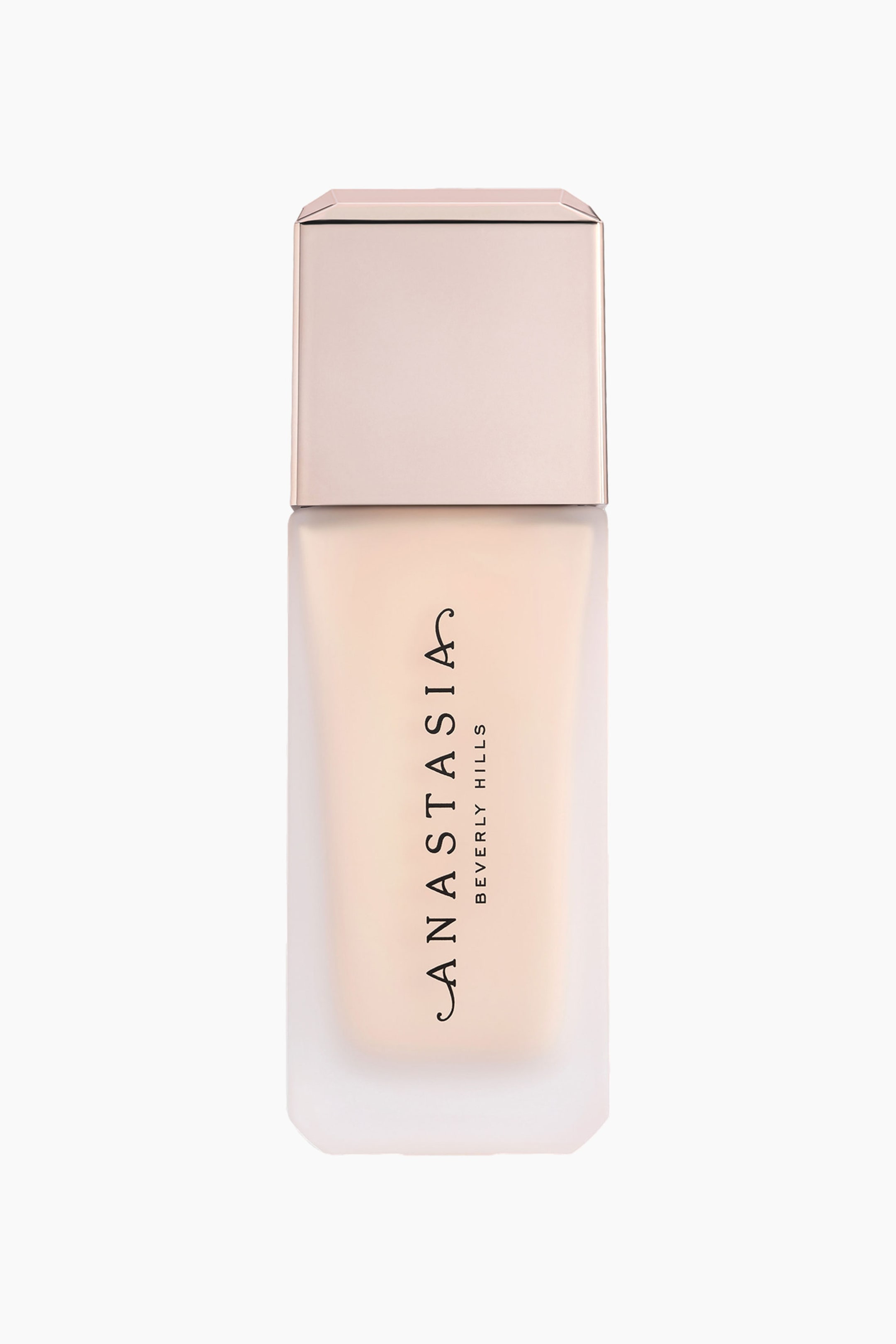 Visa större bild: En foundationflaska står upprätt, med en frostad glasflaska fylld med en ljus beige vätska. En rektangulär roséguldfärgad kork toppar flaskan, och "ANASTASIA BEVERLY HILLS" är tryckt vertikalt på framsidan.