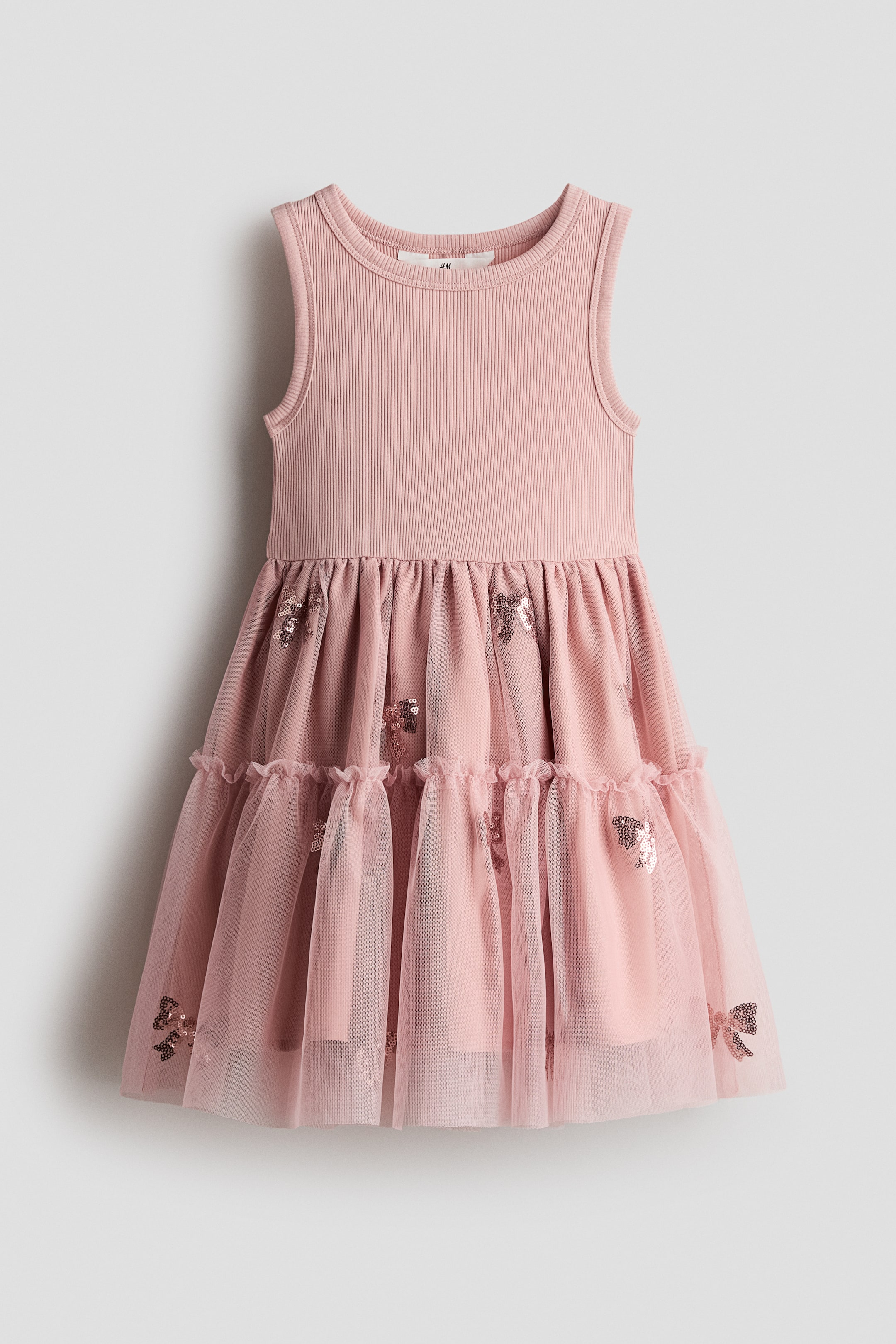 View larger image: A sleeveless dress showcasing a pink ribbed cotton jersey bodice paired with a flared, lined tulle skirt. The skirt is crafted with two tiers and adorned with scattered sequin embellishments.