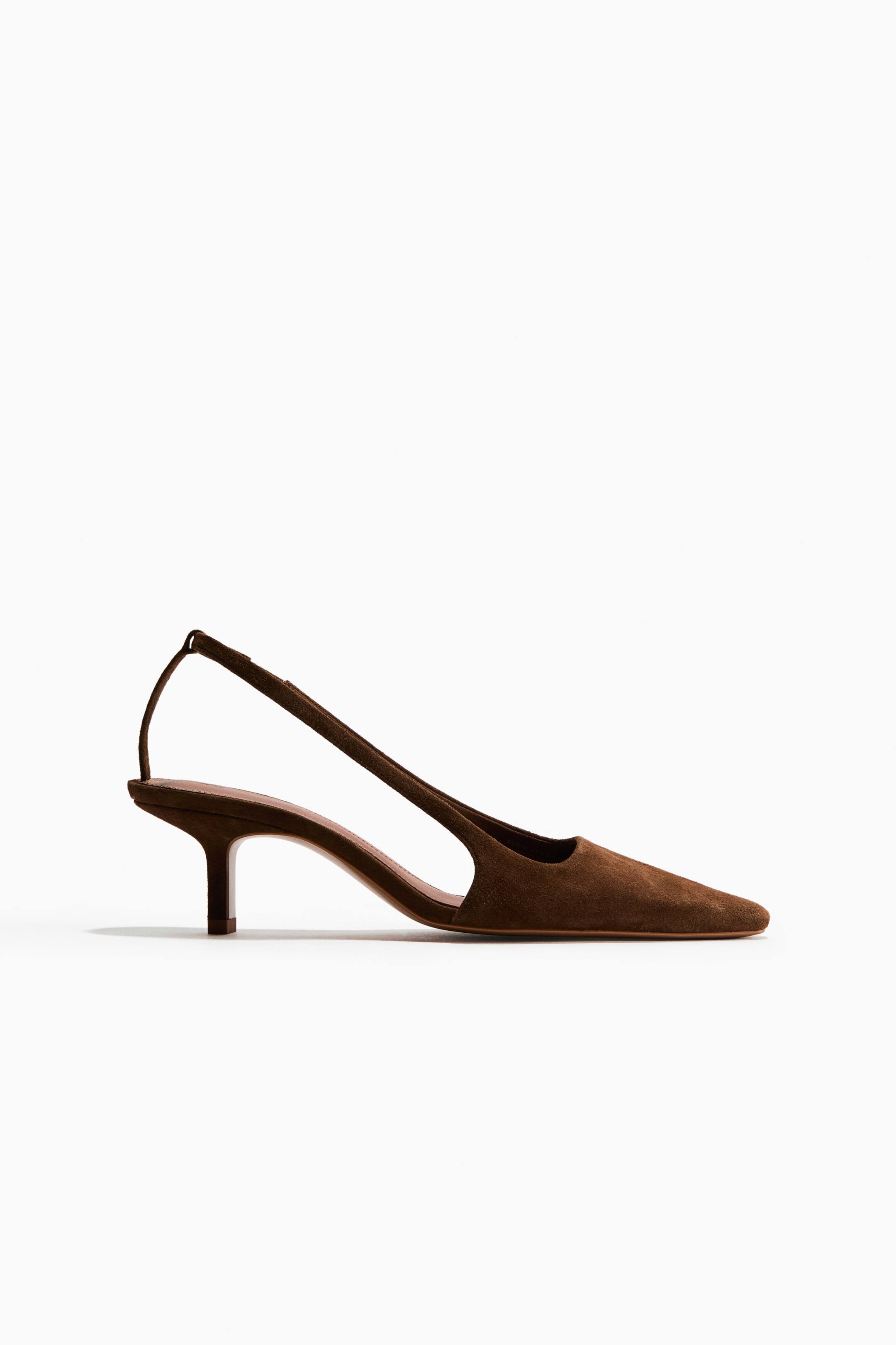 Ampliar la imagen: Un slingback de ante marrón presenta una punta afilada y un esbelto kitten heel. Un profundo recorte moldea el lateral del zapato, con una tira delgada que rodea la parte posterior.