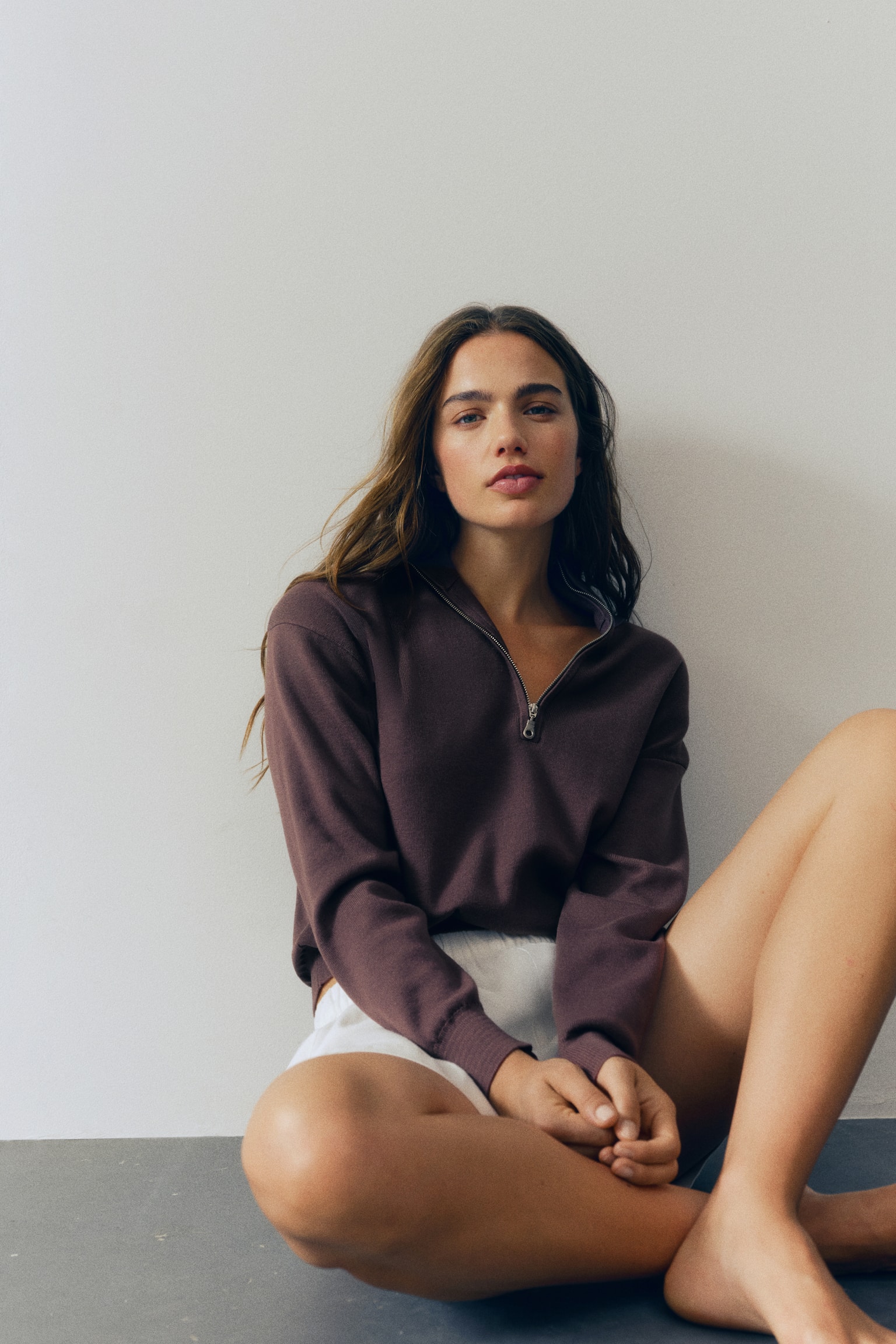 A brown quarter-zip jumper is shown front-facing, featuring a funnel neck with a silver-tone zip. It is displaying long sleeves with ribbed cuffs and a ribbed hem. - 1