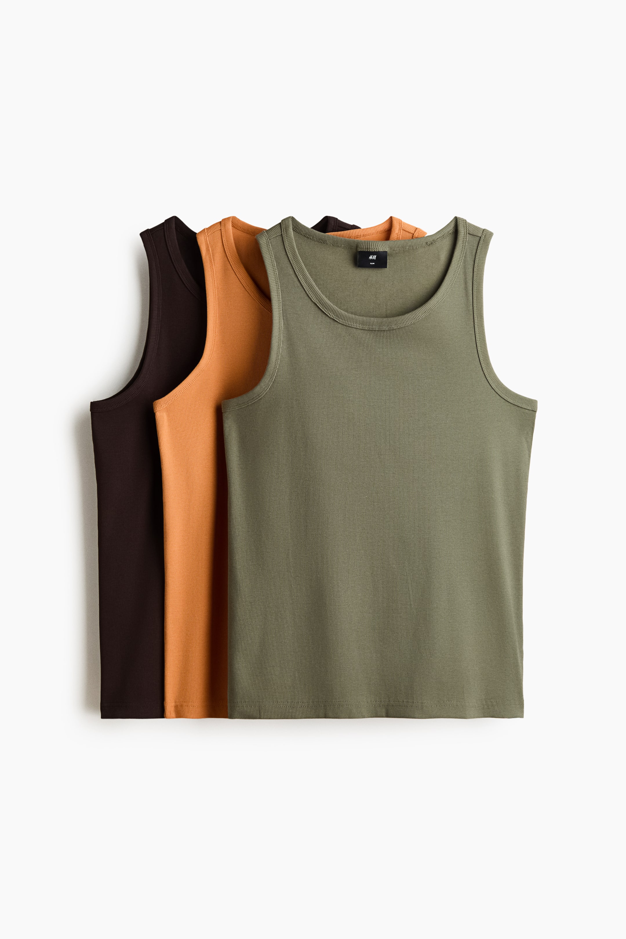 View larger image: Three ribbed jersey vest tops are displayed from the front, arranged in a stack. The top olive green vest partially conceals an orange one, which in turn partially hides a dark brown vest. Each vest is designed with a slim fit, a round neckline with ribbed detailing, and a straight-cut hem.