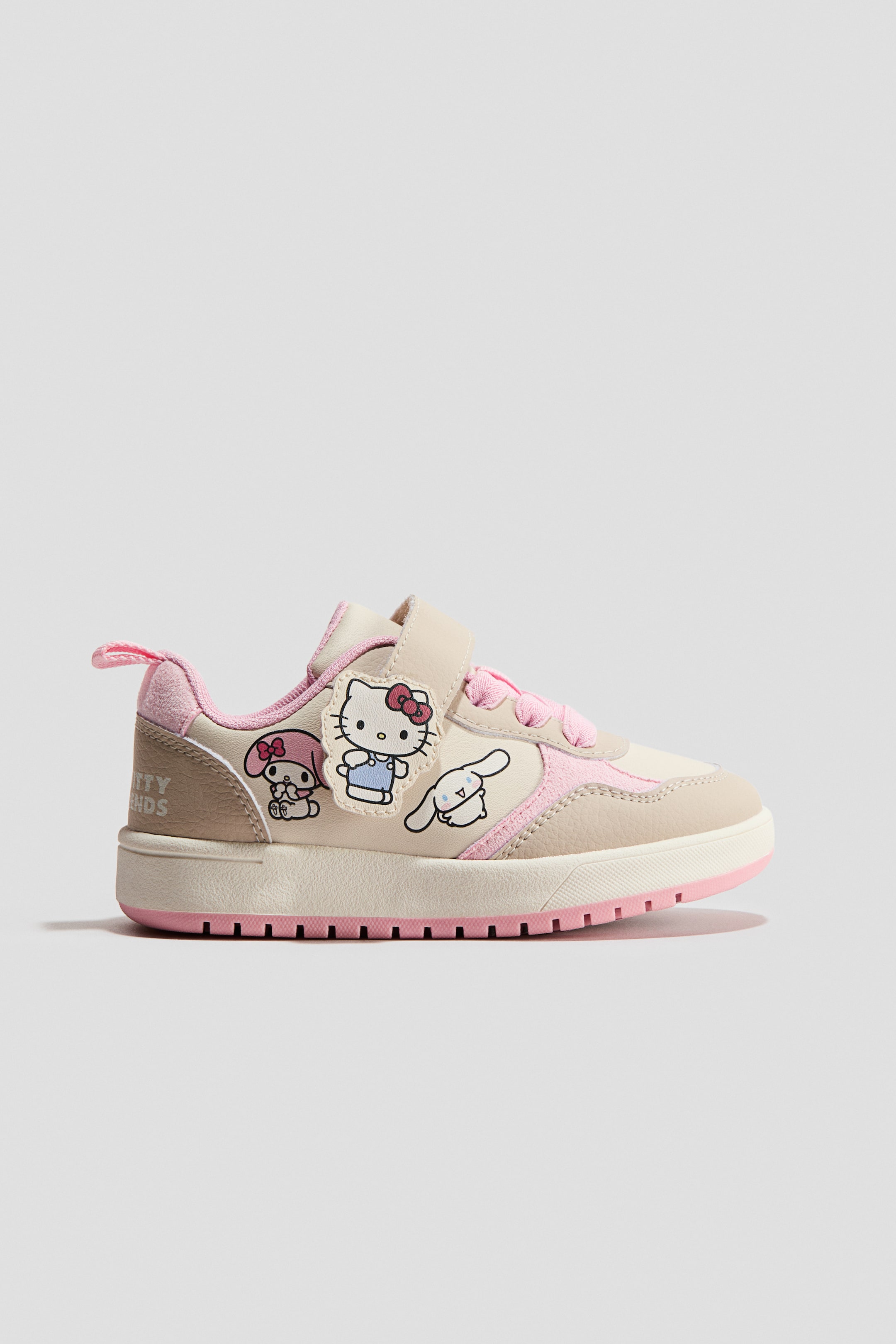 View larger image: A low-top sneaker is combining beige and pink panels, featuring Hello Kitty, My Melody, and Cinnamoroll appliqués on its side. It is designed with pink laces, a hook-and-loop strap, a thick off-white midsole, and a pink outsole featuring a textured tread.