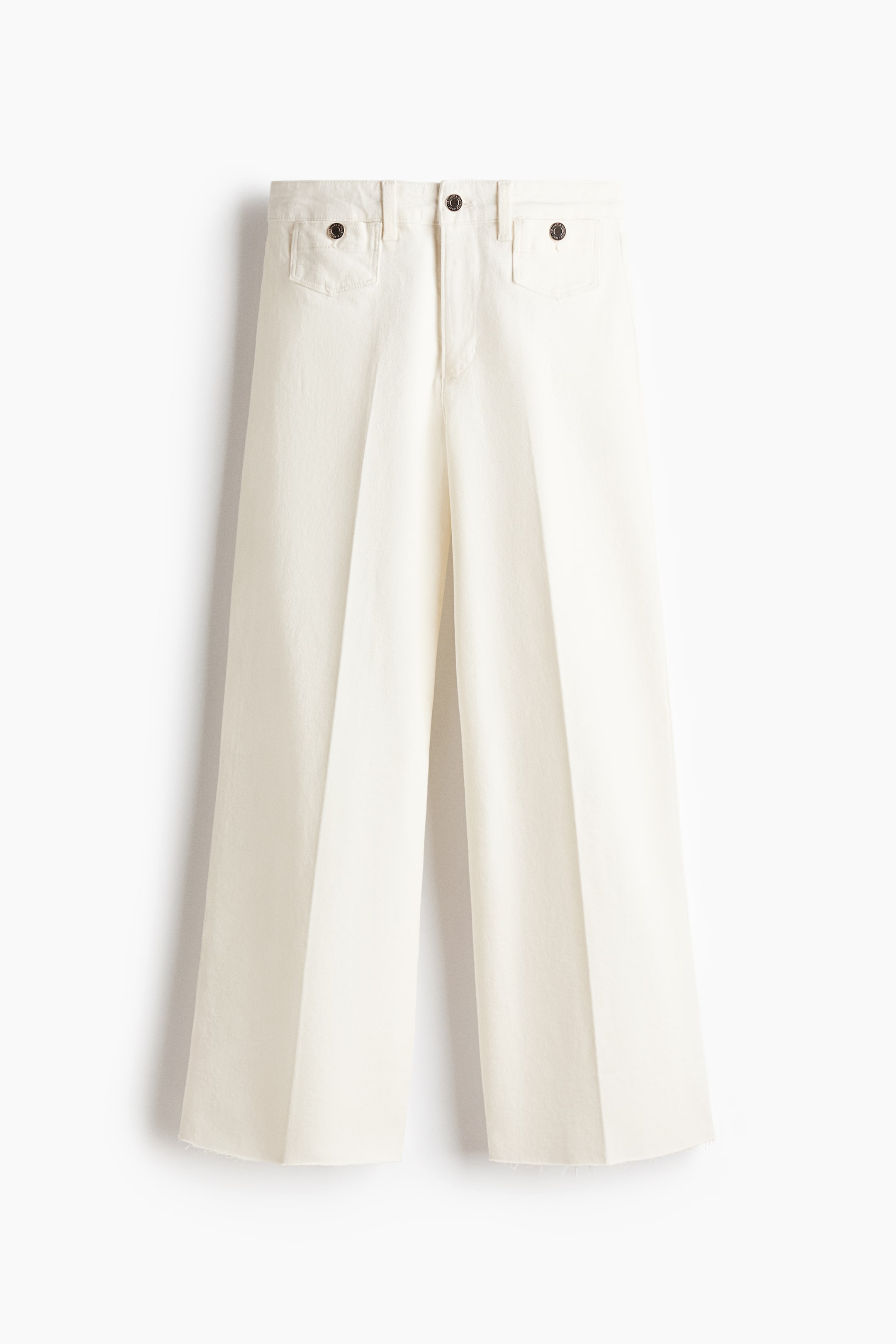 View larger image: The off-white wide-leg trousers are presenting their front, featuring a flat waistband with belt loops, button closure, and two patch pockets with button flaps at the hips. They feature a wide cut with a central crease down each leg and raw-edge hems.