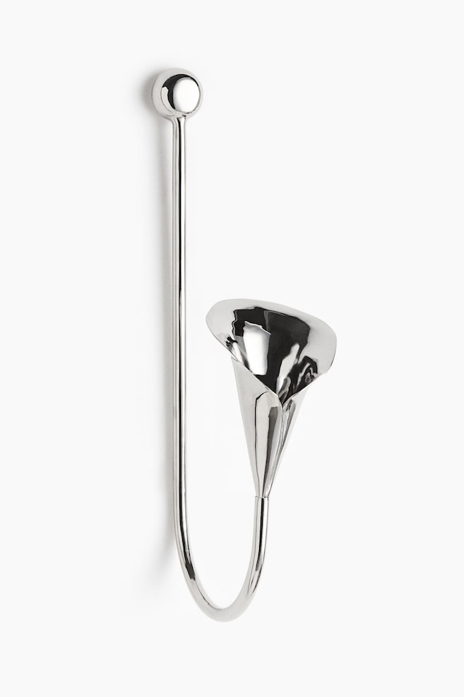 A silver-toned metal wall sconce is shown from the front, featuring a long, vertical rod with a spherical knob at the top. The rod curves upwards at the bottom, ending in a highly polished, calla lily-shaped candleholder with a reflective finish. - 1