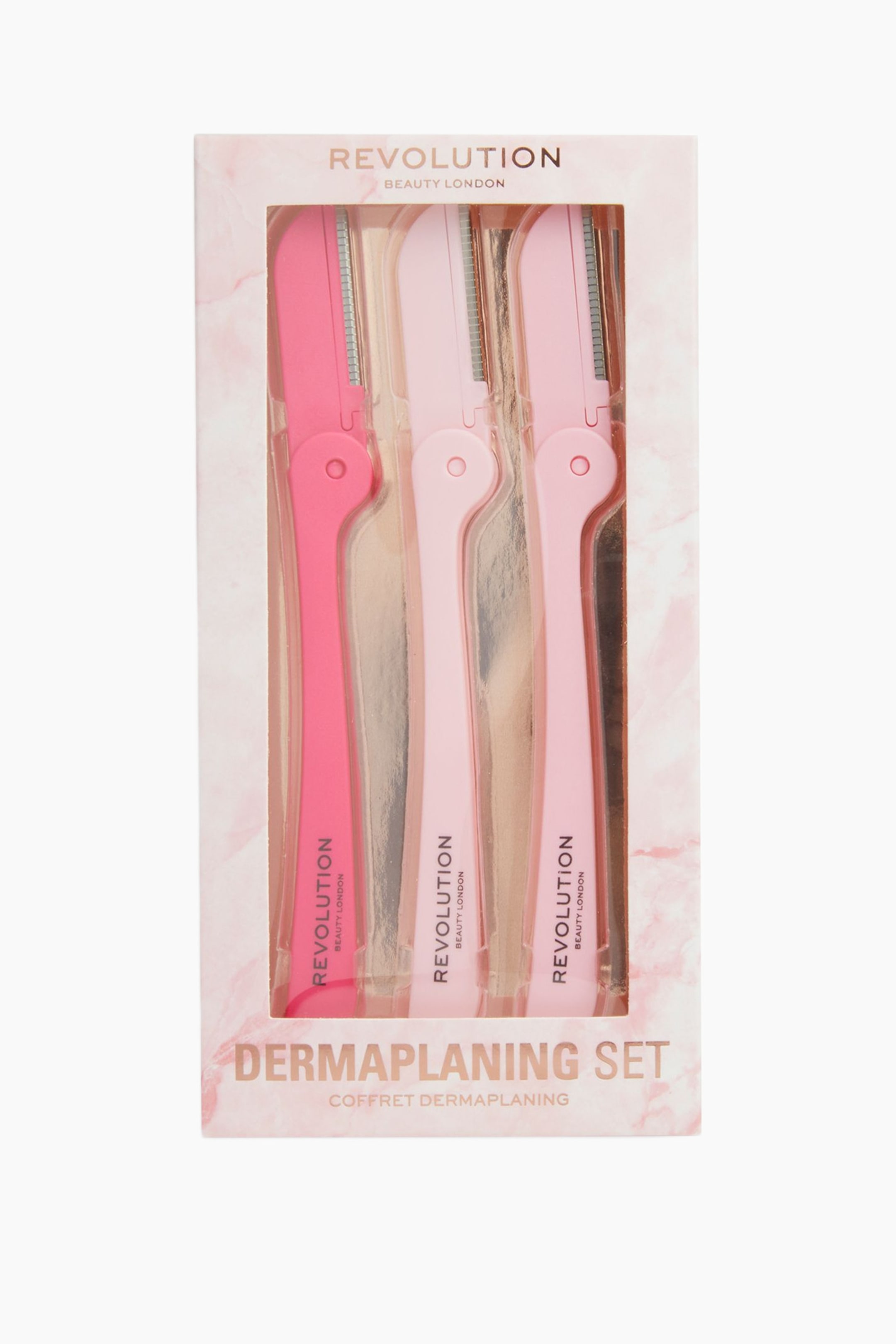 Größeres Bild ansehen: Ein verpacktes Revolution Beauty Dermaplaning Set zeigt drei Kunststoff-Dermaplaning-Tools in verschiedenen Rosatönen in einer hellrosa Box mit Marmoroptik und einer transparenten Frontfenster. Die Tools stehen aufrecht und präsentieren ihre Metallklingen mit Sicherheitsabdeckungen an der Oberseite sowie den Markennamen, der entlang der Griffe aufgedruckt ist.