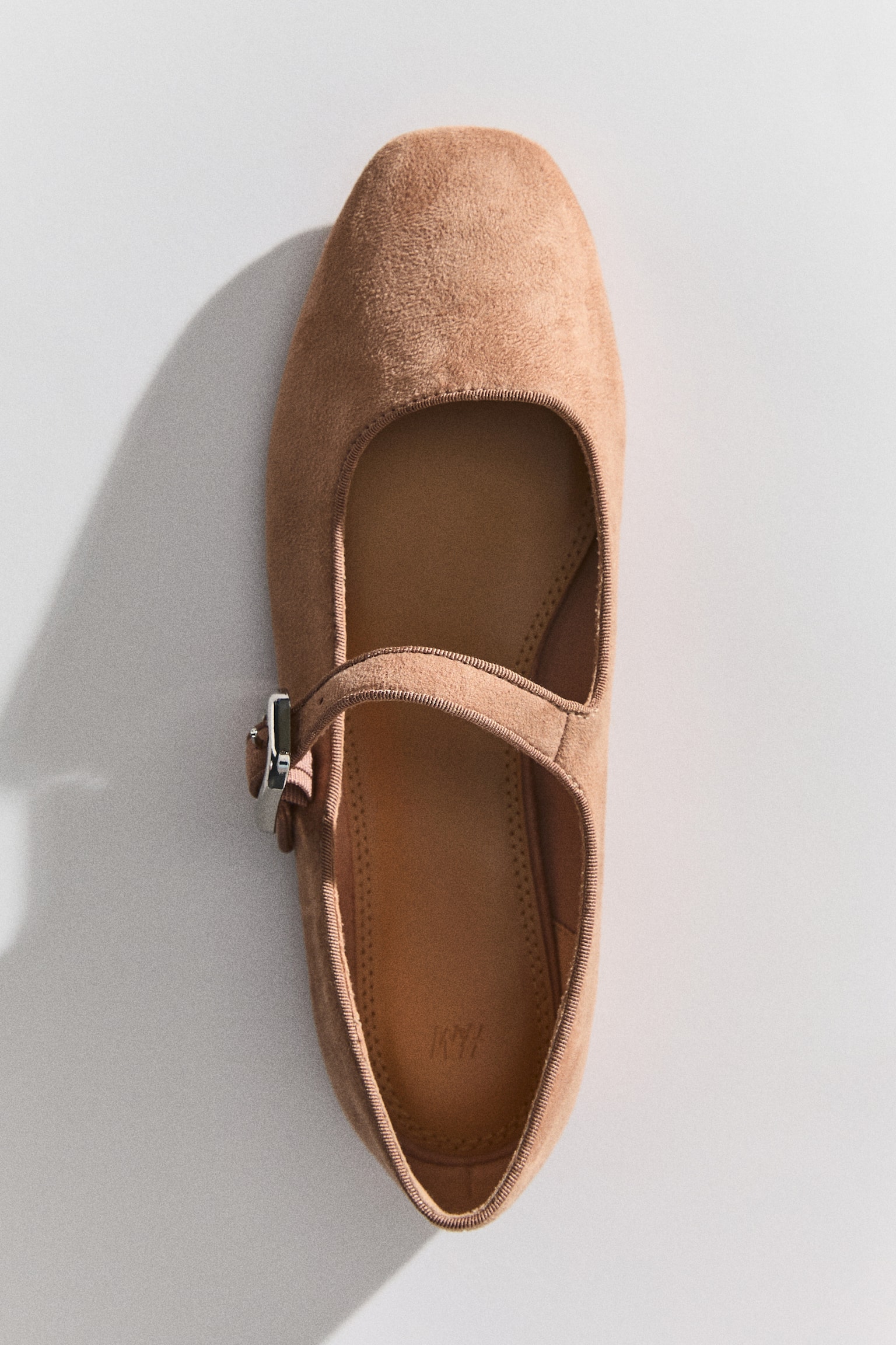 A taupe suede Mary Jane flat shoe is facing right, featuring a pointed toe. A single strap with a silver-toned rectangular buckle is crossing the instep. - 1