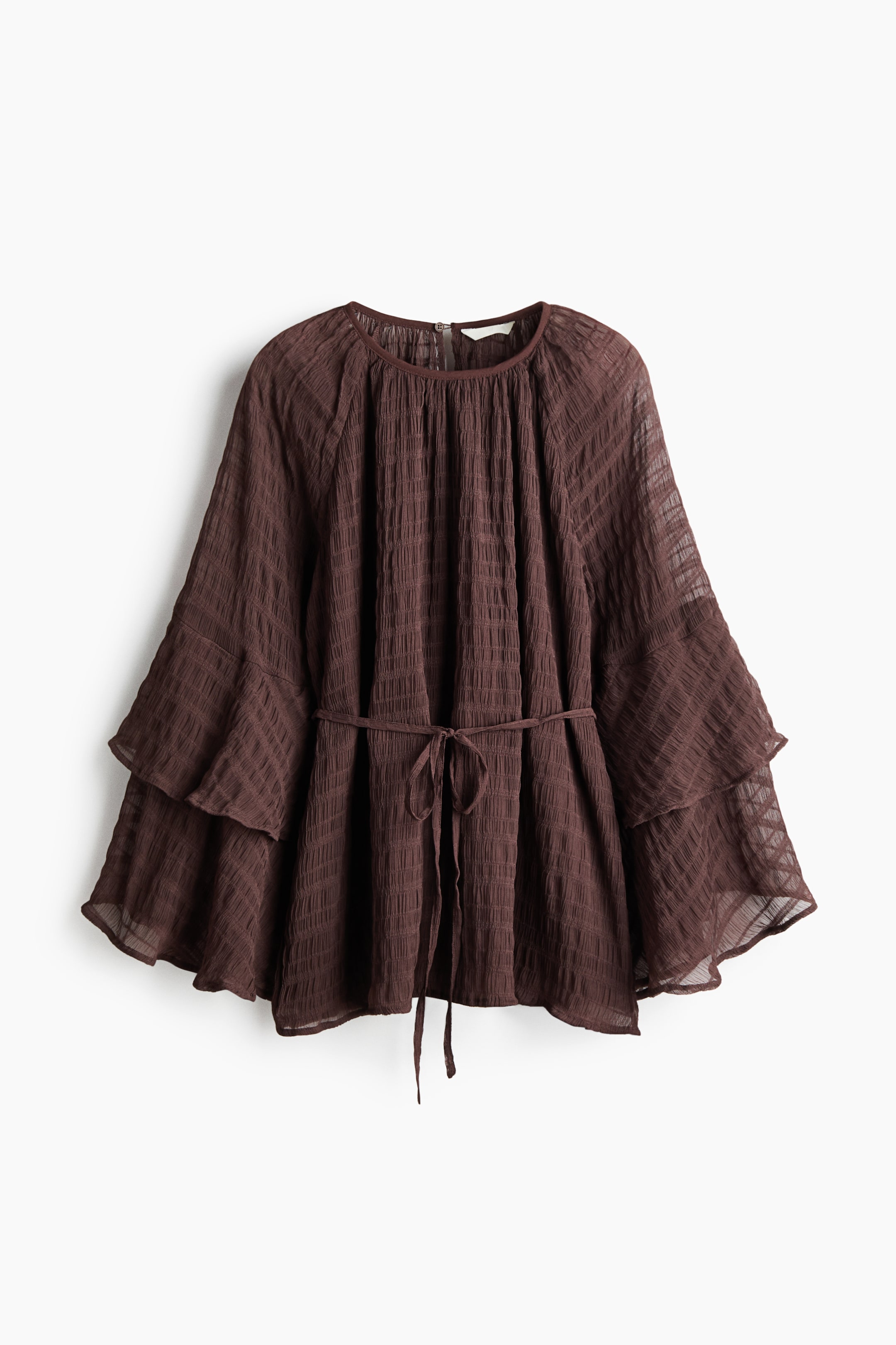 View larger image: The dark brown blouse showcases its front profile, highlighting a round gathered neckline and long, tiered bell sleeves. Crafted from a sheer, crinkled fabric with a subtle checked pattern, the blouse features a self-fabric tie cinching the waist, elegantly tied in a bow.