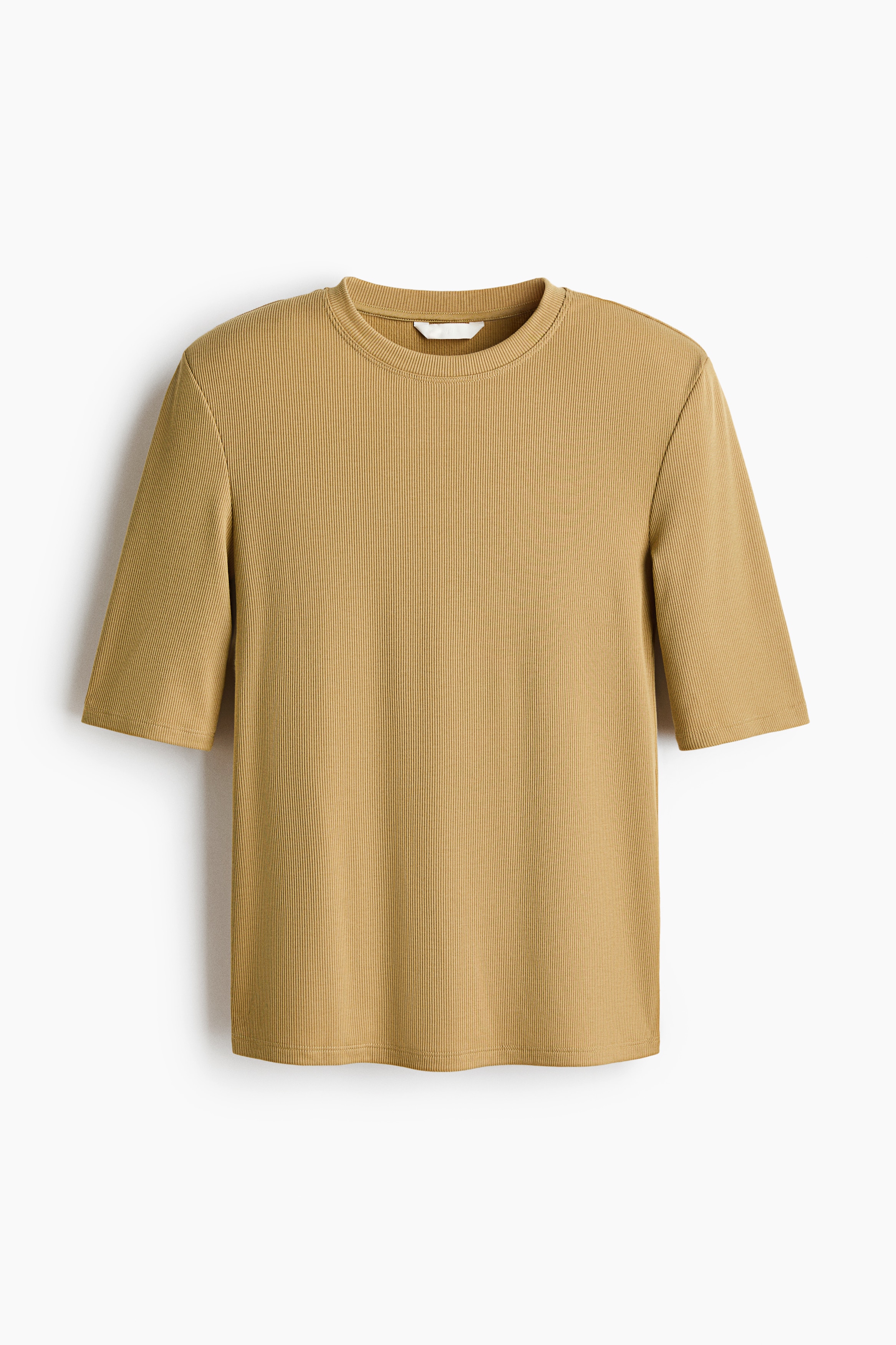 A mustard-colored fitted tee in ribbed jersey is being worn by the model, featuring structured shoulder pads, a round neckline, and elbow-length sleeves. The tee is styled over black jeans with a black buckled belt.