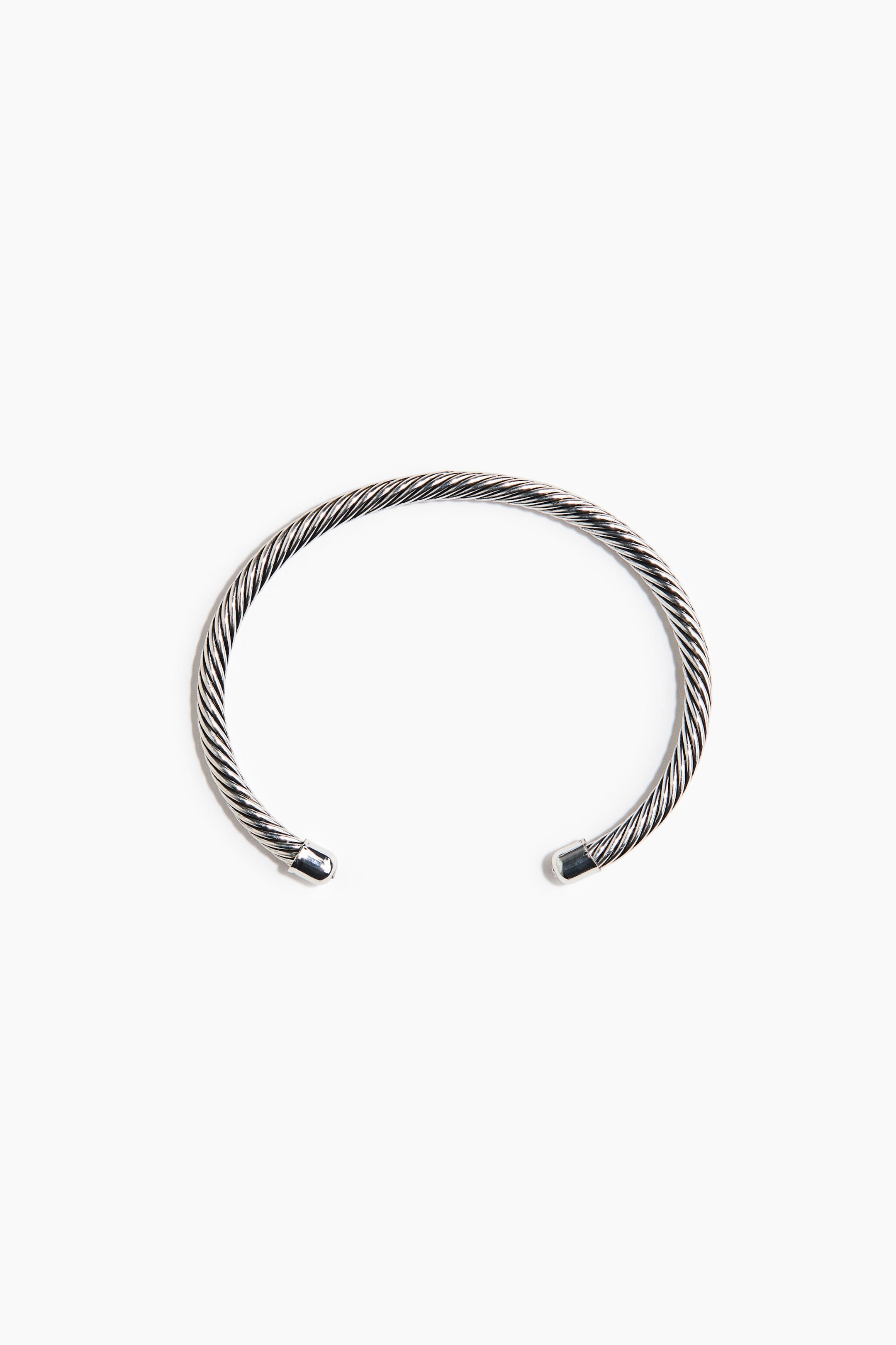 View larger image: A silver-toned cuff bracelet features a twisted cable design, with smooth, rounded caps at its open ends.