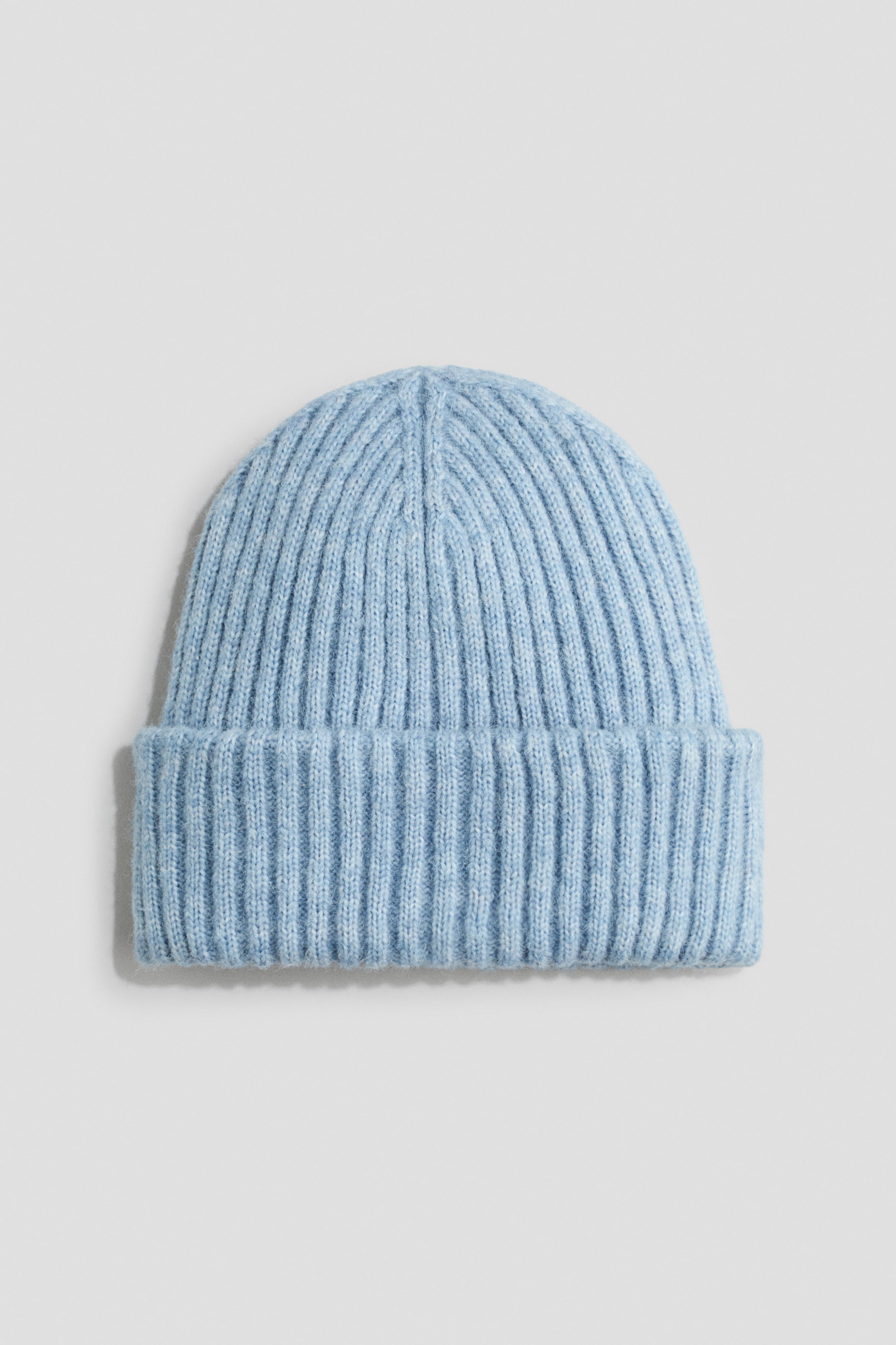 Grösseres Bild ansehen: Eine hellblaue Beanie aus weichem Rippstrick ist von vorne zu sehen und verfügt über einen breiten Umschlag und eine abgerundete Krone mit vertikaler Rippstruktur.
