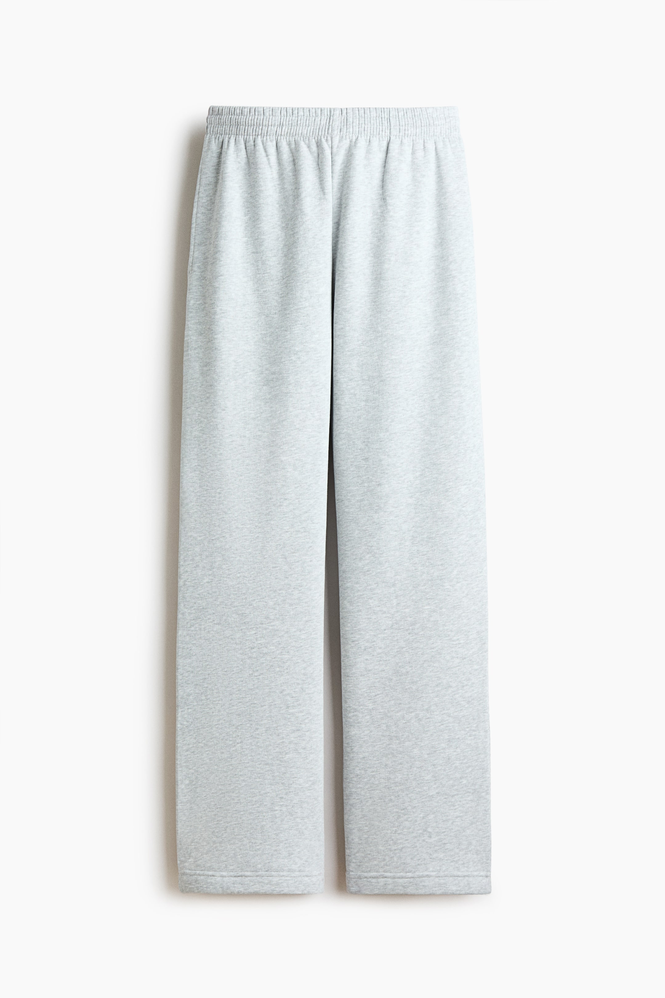 View larger image: Light gray sweatpants made from sweatshirt fabric are displayed frontally, laid flat. They feature an elasticated, smocked waist, side pockets, and straight legs.