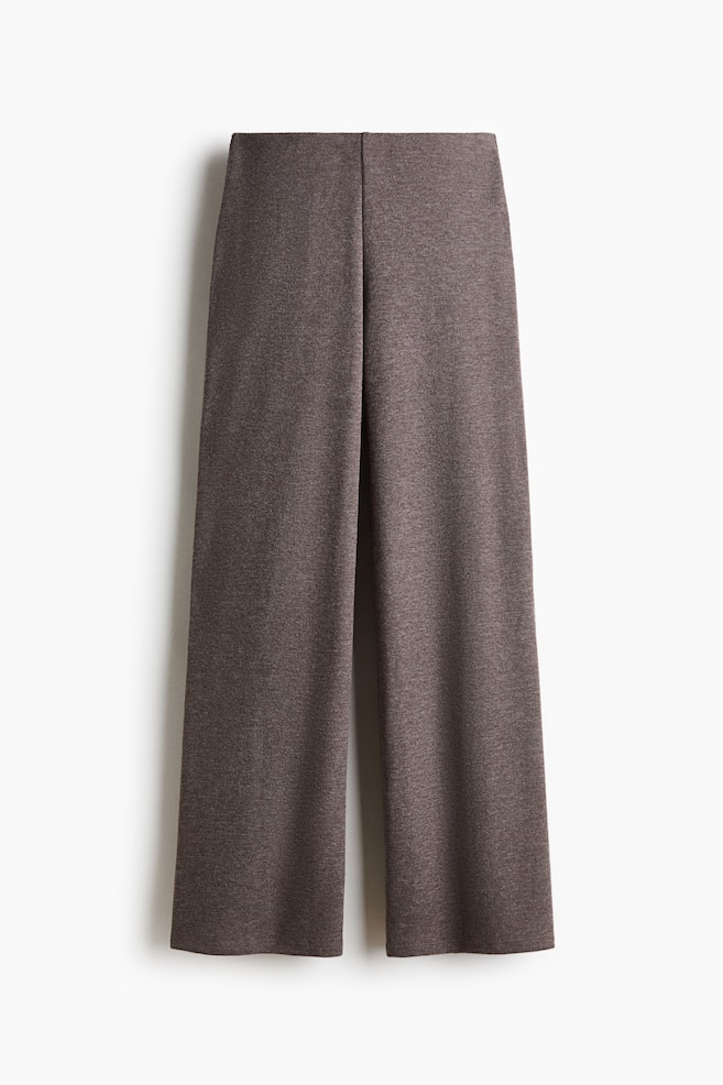 Relaxed-fit trousers in a soft, heathered brown knit are hanging in a front view, showcasing a clean waistband and wide, straight legs. - 1