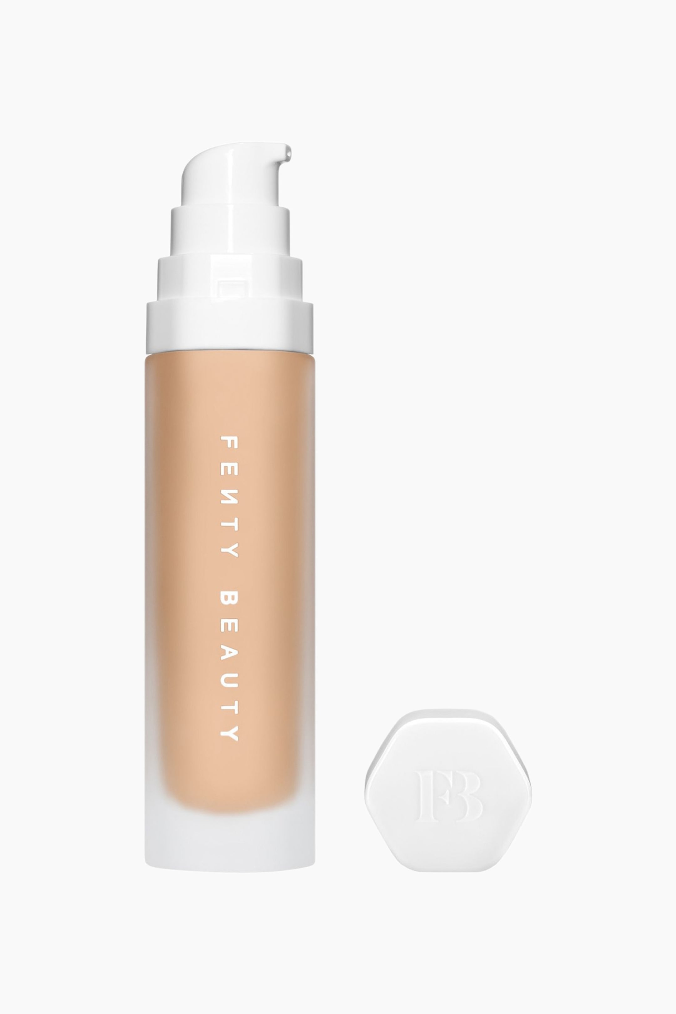 Visa större bild: Soft'lit Naturally Luminous Longwear Foundation står upprätt och visar upp en frostad glasflaska fylld med en ljus till medelbeige vätska, med vertikal vit branding tryckt på flaskan. En vit, stegad pumpdispenser sitter monterad upptill, och bredvid ligger ett separat vitt hexagonalt lock med en präglad logotyp.