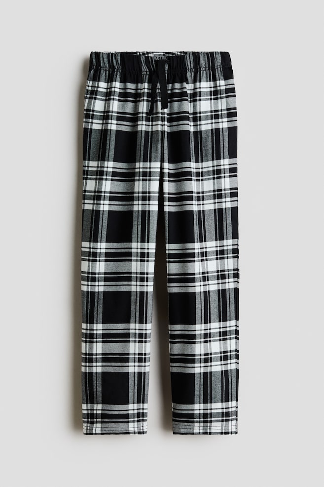 Pyjamahose im schwarz-weiÃen Karomuster, von vorne gezeigt, mit geradem Hosenbein. Die Hose ist mit einem gesmokten, elastischen Bund und einem schwarzen Kordelzug versehen, der mittig gebunden ist. - 1