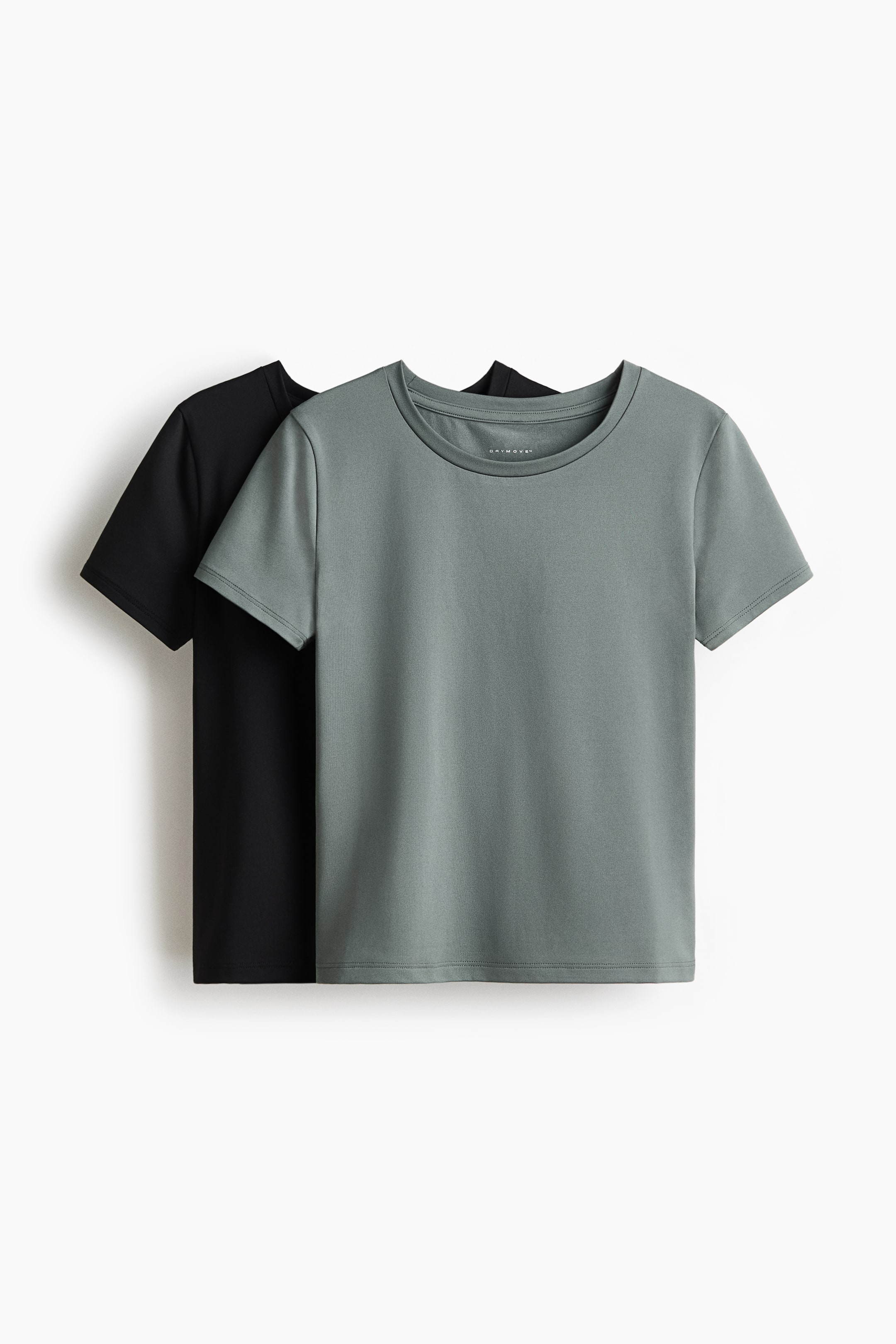 Näytä suurempi kuva: Kaksi lyhythihaista urheilutoppia on esitetty edestäpäin: yksi harmaa-vihreä ja yksi musta, hieman päällekkäin. Etualalla oleva harmaa-vihreä toppi on pyöreällä pääntiellä, ja sen sisäpääntiössä näkyy "DryMove?"-etiketti, kun taas musta toppi on sen takana.