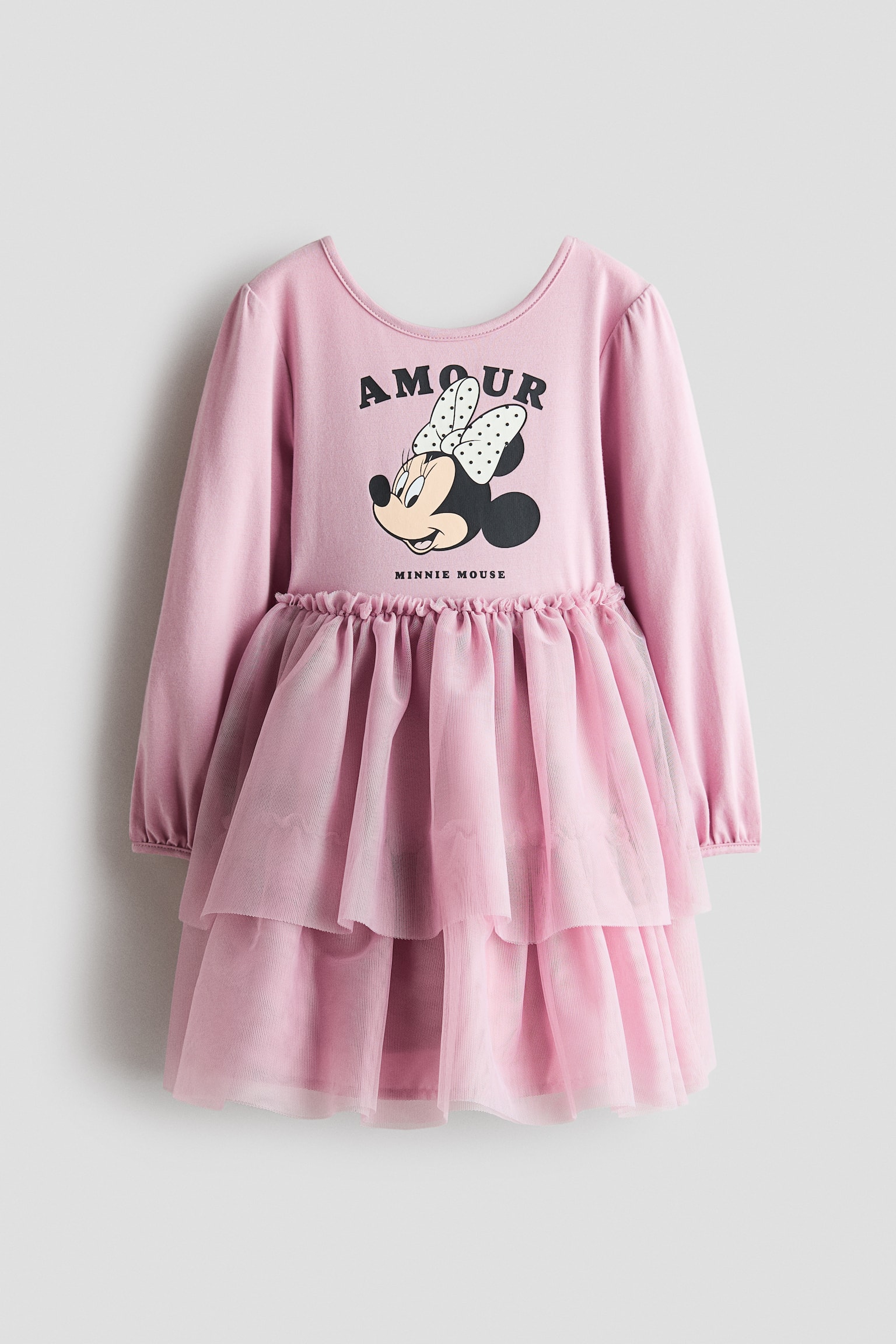 ä¸ä»¶æ·ºç²è²é·è¢ç«¥è£æ´è£æ­£é¢å±ç¤ºï¼å·æåé é å£ï¼è¸åå°æ Minnie Mouse åæ¡ï¼ä¸æ¹æ±å½¢å­æ¨£çºãAMOURããéä»¶æ´è£æ¡ç¨åå±¤è·èéèç´è£è¥¬ï¼ä¸¦å¨è°é¨åäºèçºè¨­è¨ã