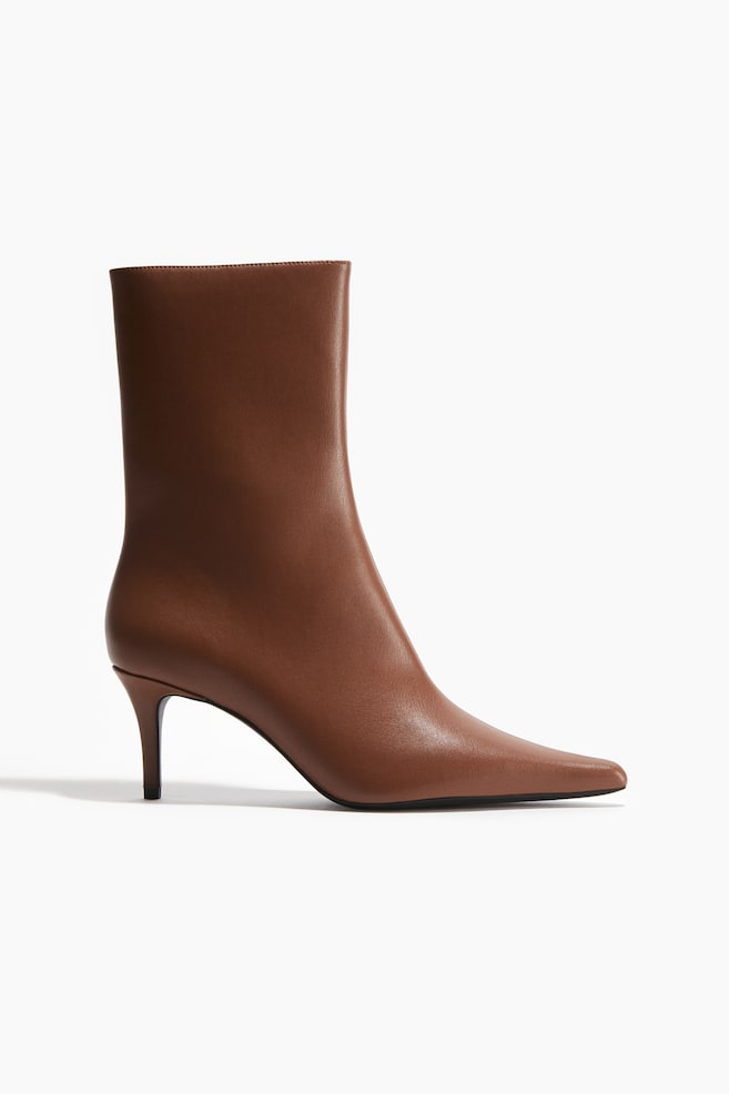 A single brown leather ankle boot is shown from a side-front angle, featuring a sleek, pointed toe and a slender kitten heel. - 1