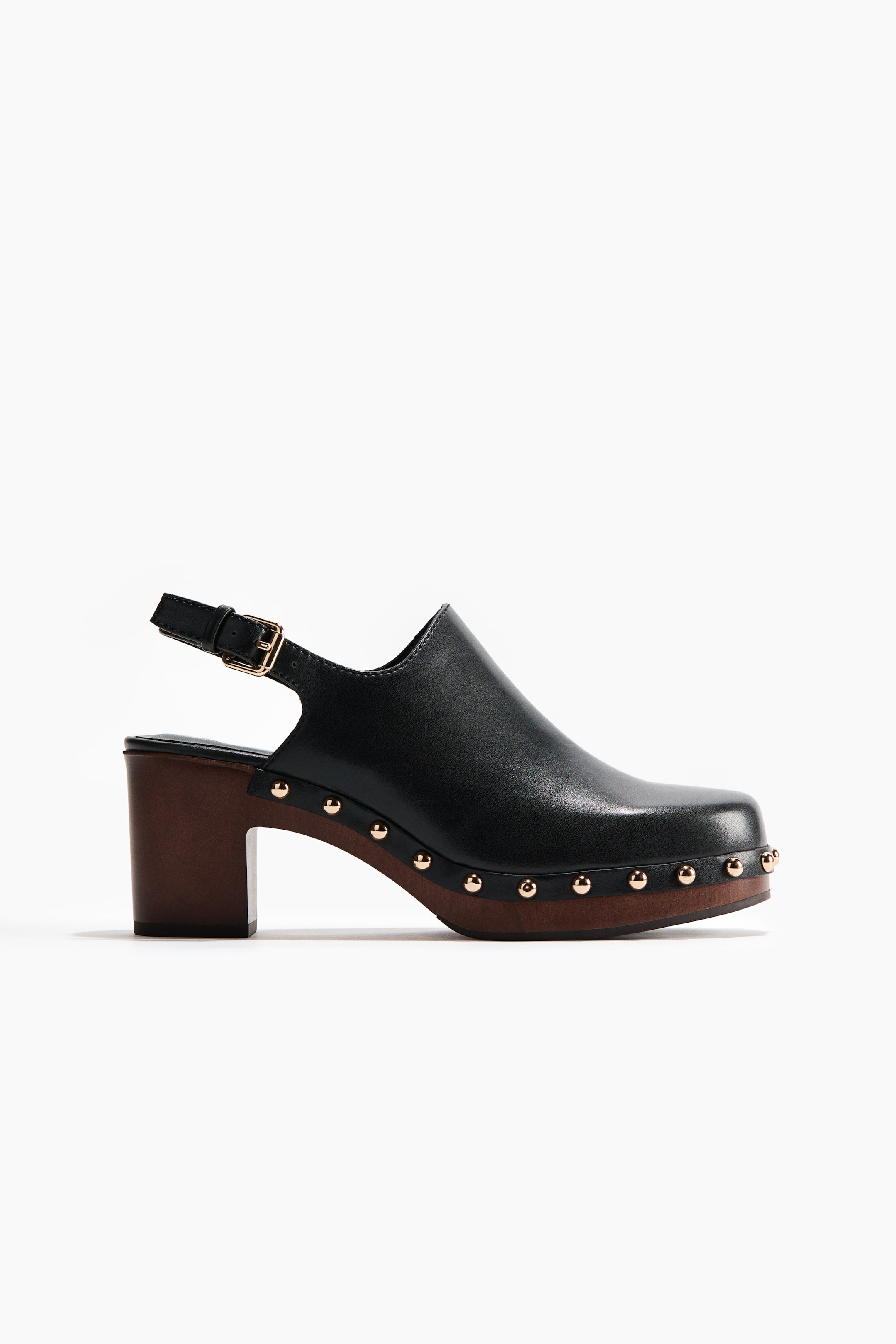 View larger image: A black leather clog-style mule with a squared toe, featuring a dark brown block heel and platform sole, finished with gold-tone studs along the edge where the upper meets the sole. An adjustable strap with a gold-tone buckle is visible at the back.