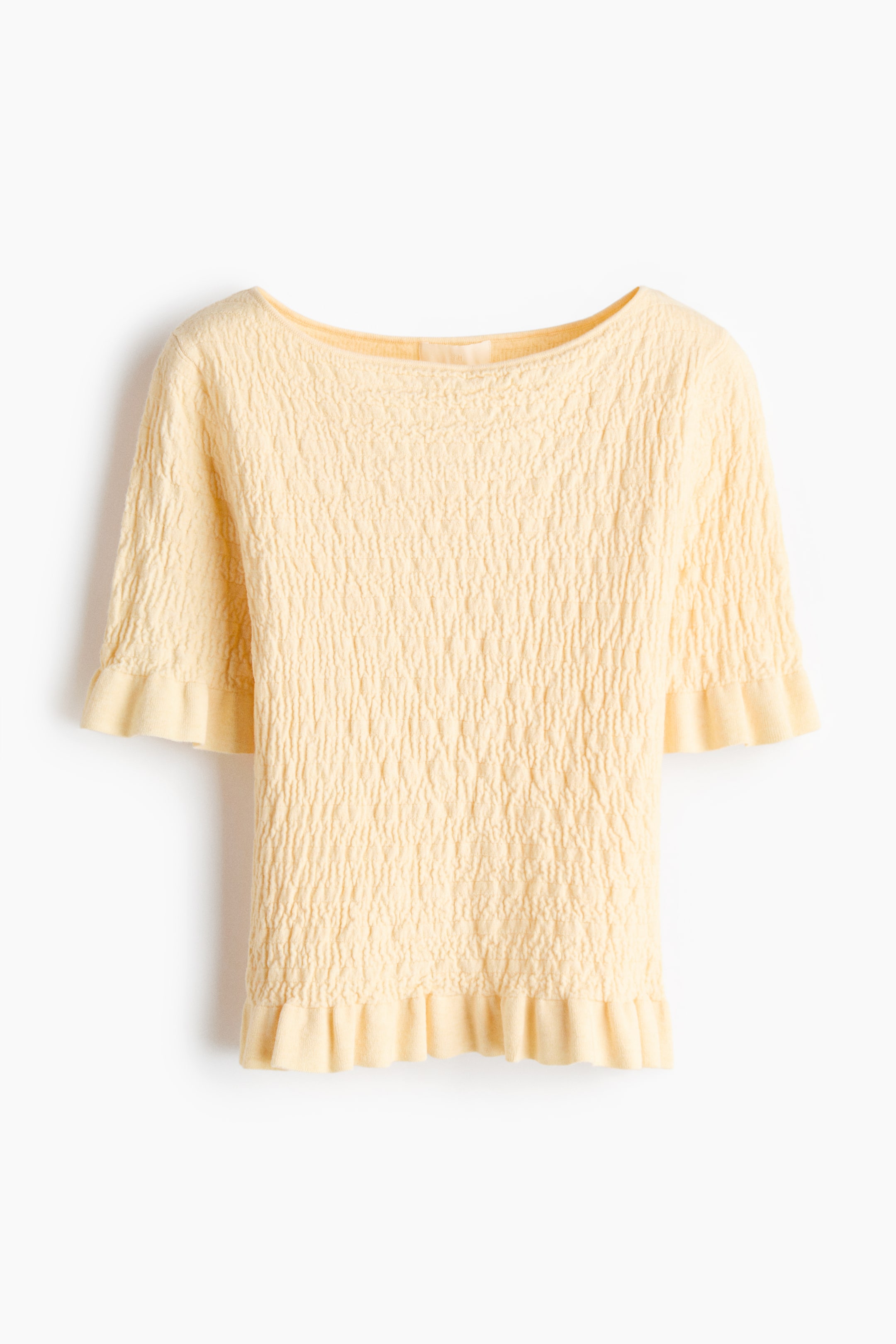 View larger image: A light yellow top is facing front, showcasing a crinkled texture across its main body and short sleeves, and featuring a boat neckline with ruffled edges on both the sleeve cuffs and the bottom hem.